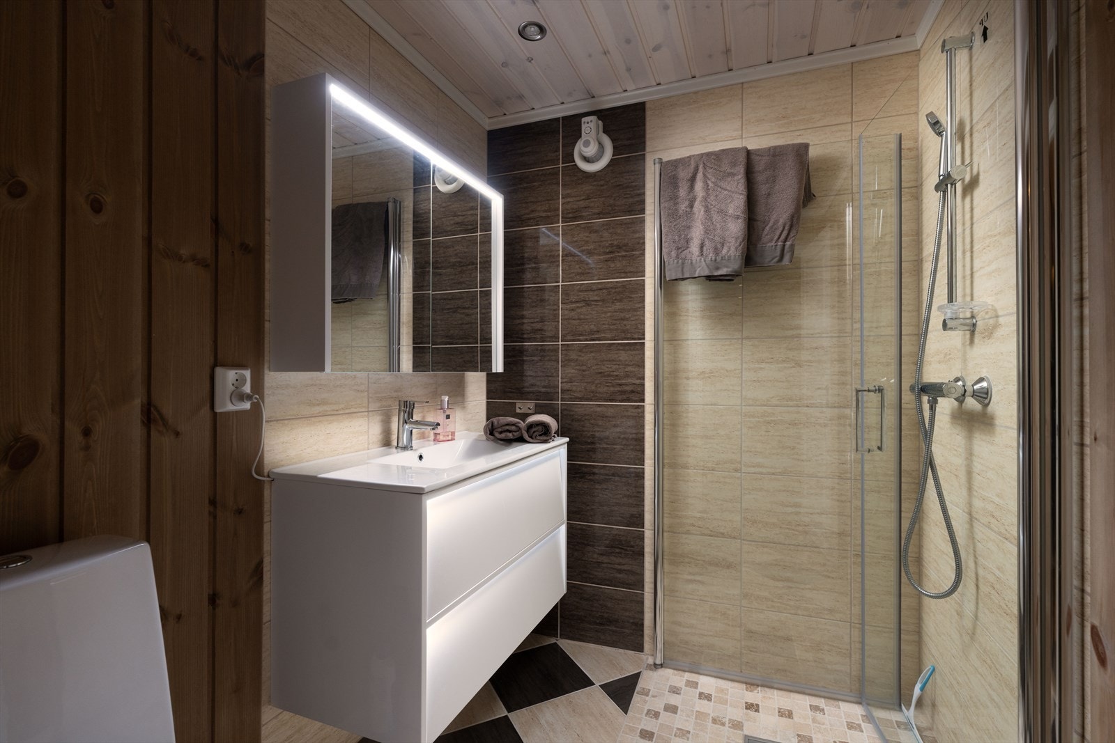 Begge har flislagte gulv med gulvvarme, servant, wc og dusjhjørne. Galleribilde