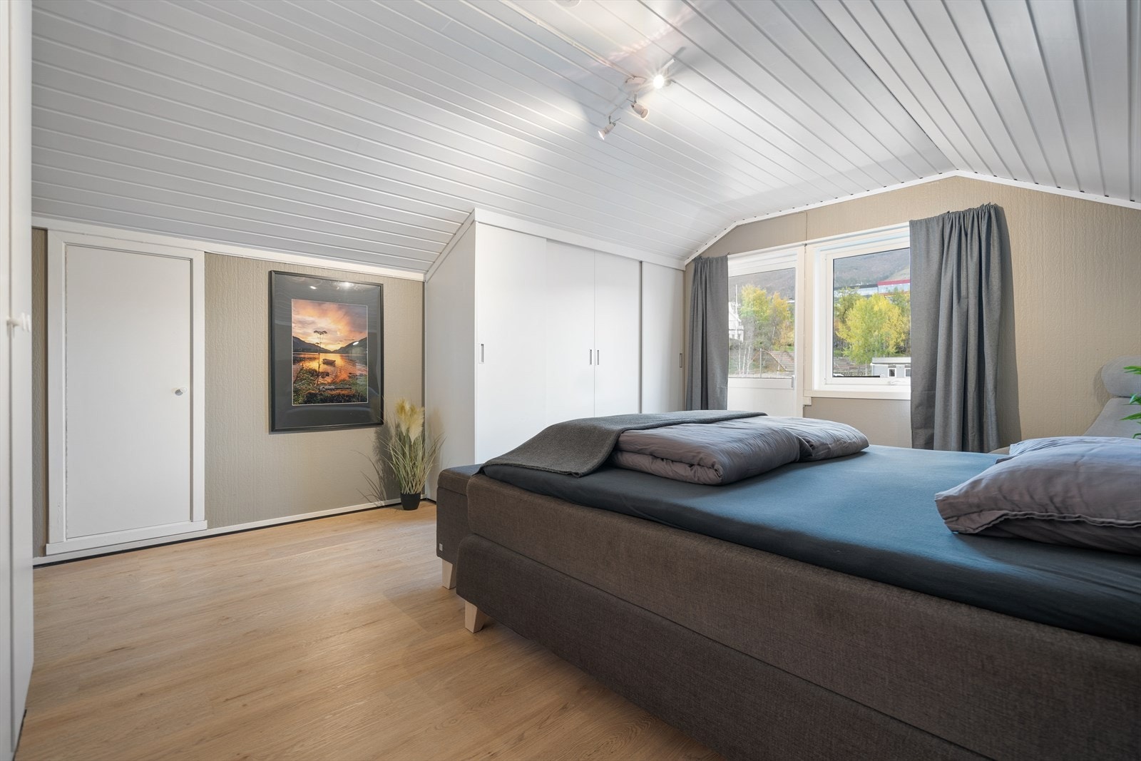 Lyse fargetoner og store vinduer gir rommet et luftig preg. Her er det god plass til oppbevaring og et helhetlig, stilrent uttrykk Galleribilde