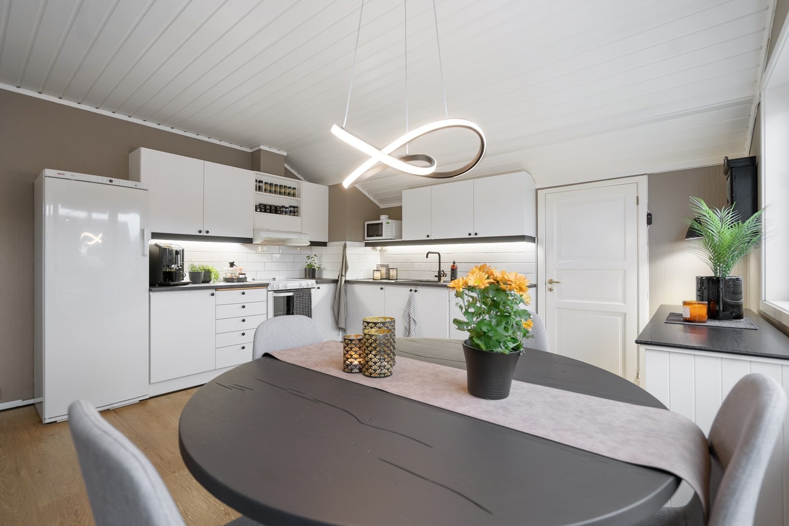 Kjøkkenet har en klassisk og ren utforming med plass til alt du trenger. Kombinasjonen av lyse flater og mørke detaljer gir et elegant uttrykk Galleribilde