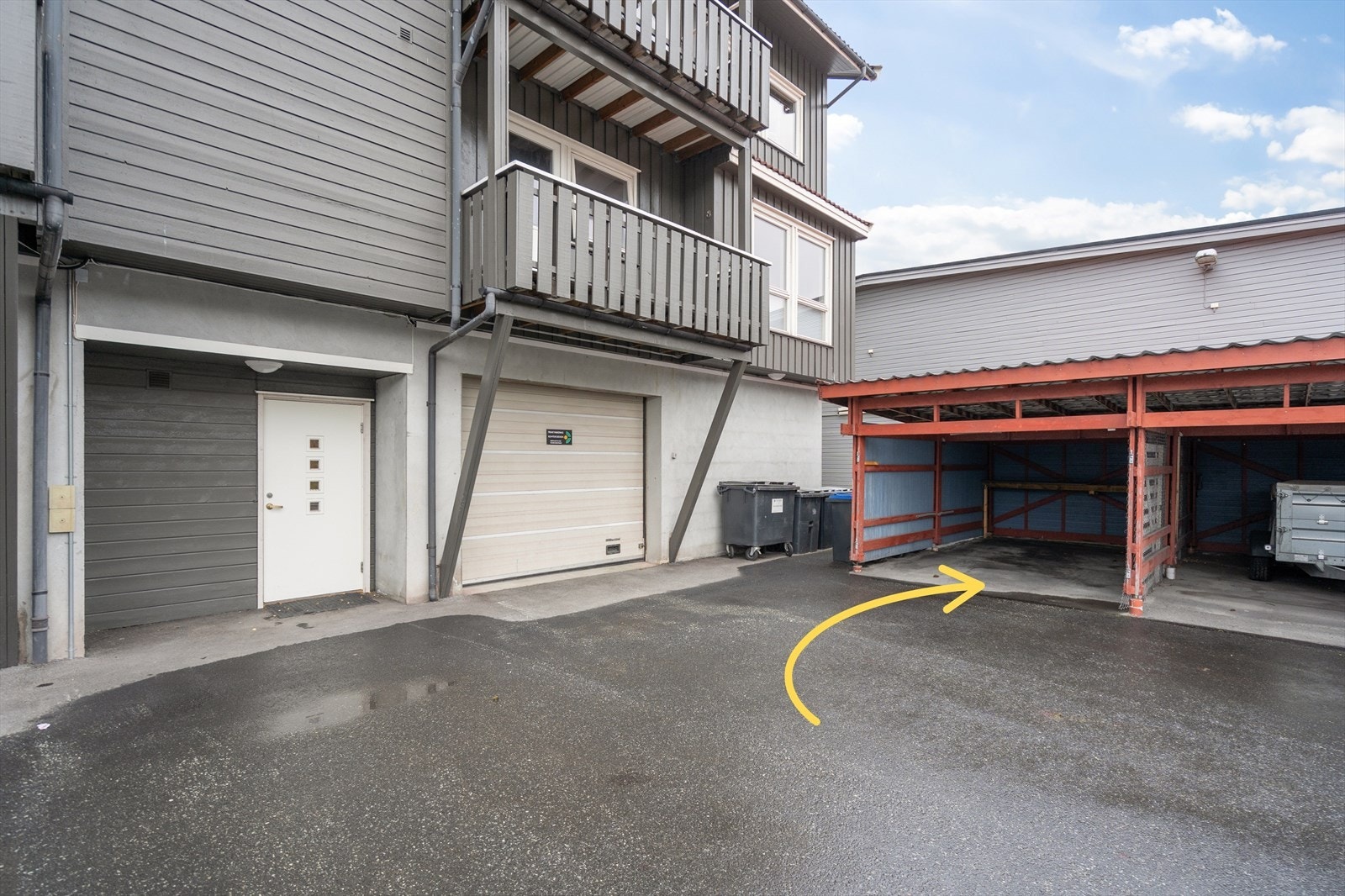 Bak bygget finner du carport og inngang fra denne siden av bygget - perfekt for deg som ønsker å gå tørrskodd fra bilen og inn i oppgangen Galleribilde