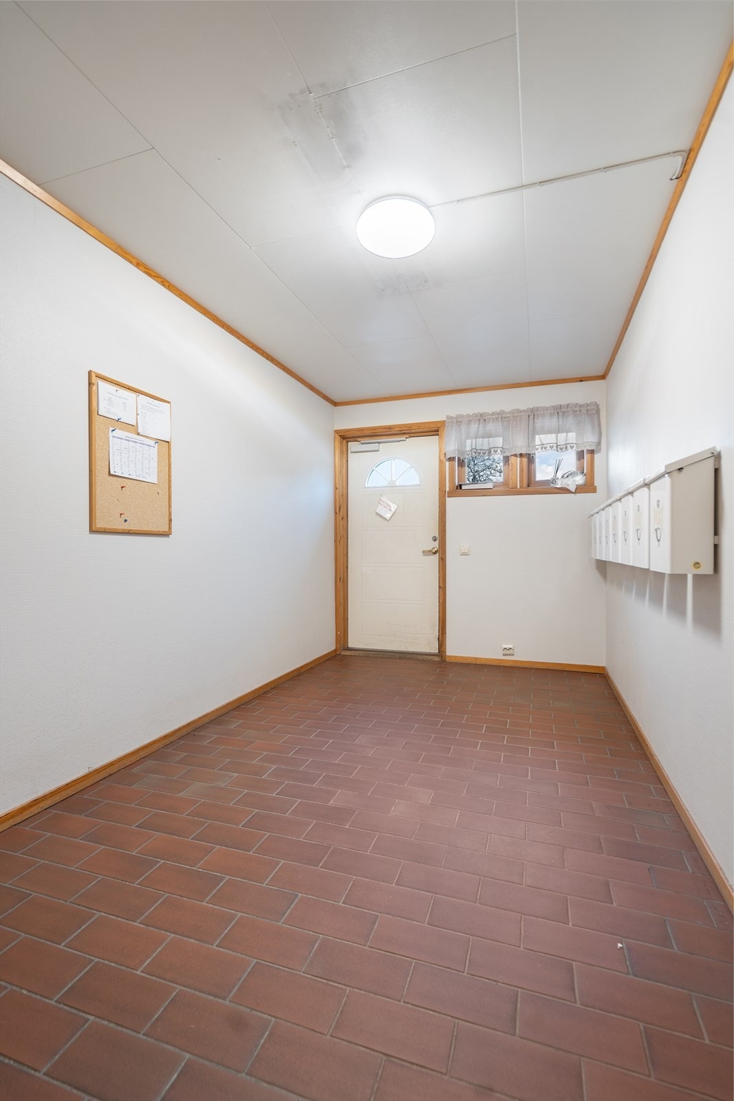 Velstelt felles entré med flislagt gulv og postkasser Galleribilde