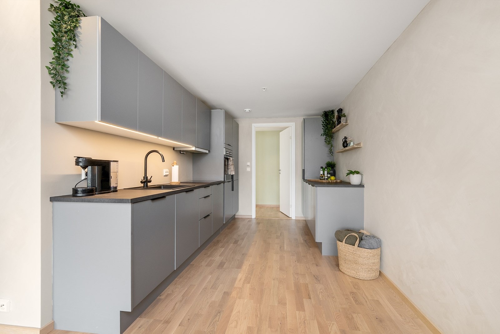 Det er godt med skap- og benkeplass i den stilrene kjøkkeninnredningen som er i grå utførelse med sorte detaljer. Galleribilde