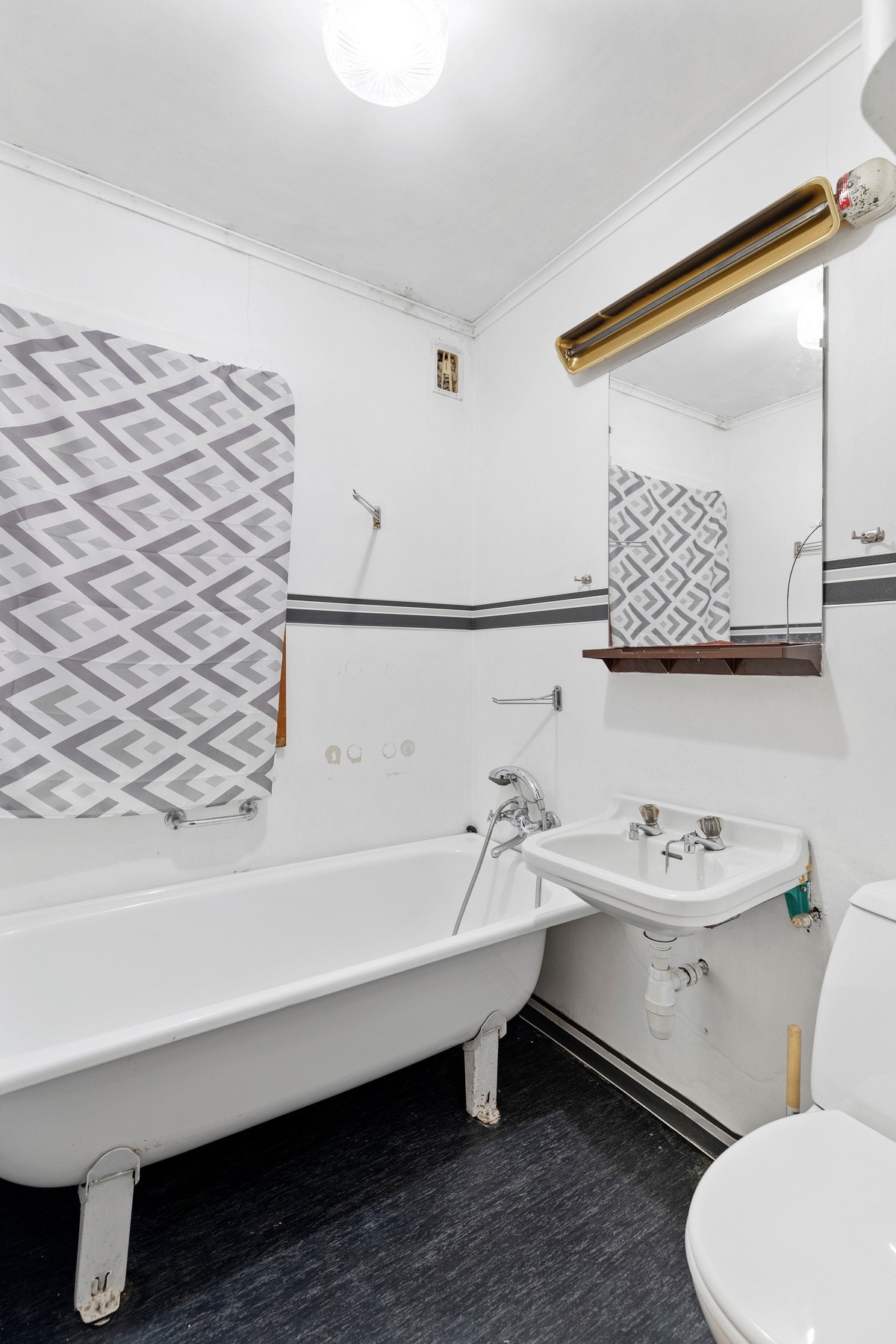 Badet i etasjen har belegg på gulv og malte flater på vegger. Rommet er utstyrt med badekar, servant og toalett. Galleribilde