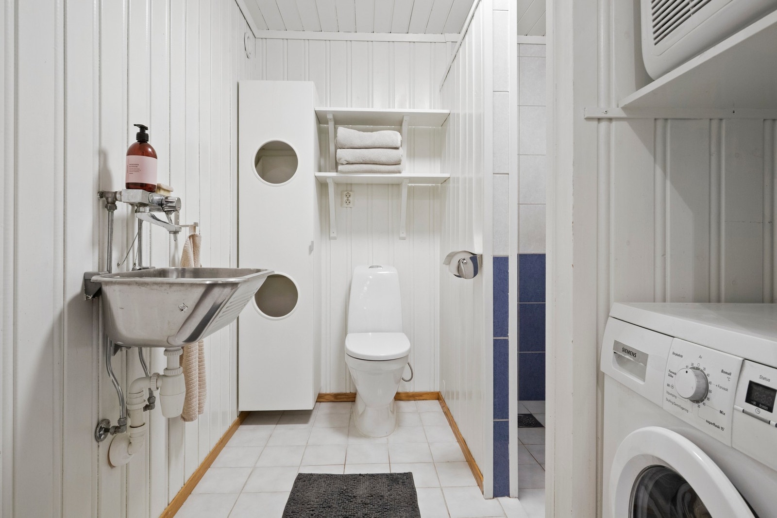 Badet/vaskerommet nede har hvite gulvfliser med varme. Galleribilde