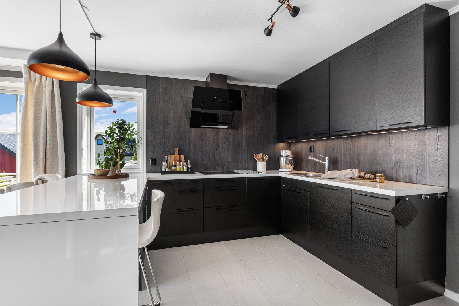 Stilrent kjøkken med mørke fronter, integrerte hvitevarer og god benkeplass. Et funksjonelt og moderne rom med tidløs design. Galleribilde