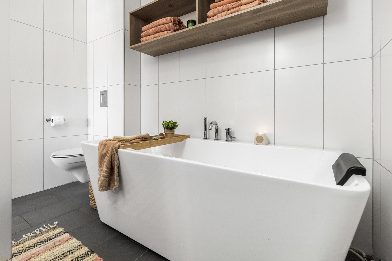 Stilrent bad med frittstående badekar, god oppbevaring og delikate detaljer som skaper en lun og avslappende atmosfære. Galleribilde