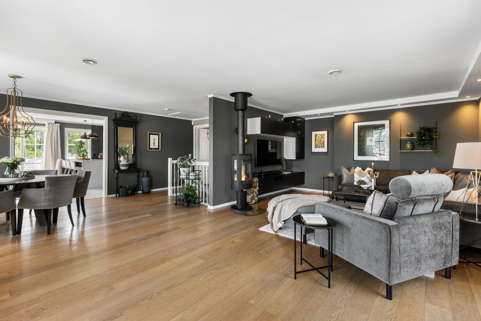 Åpen og romslig stue- og spisestueløsning med moderne detaljer, vedovn og store vindusflater som slipper inn rikelig med dagslys. Galleribilde