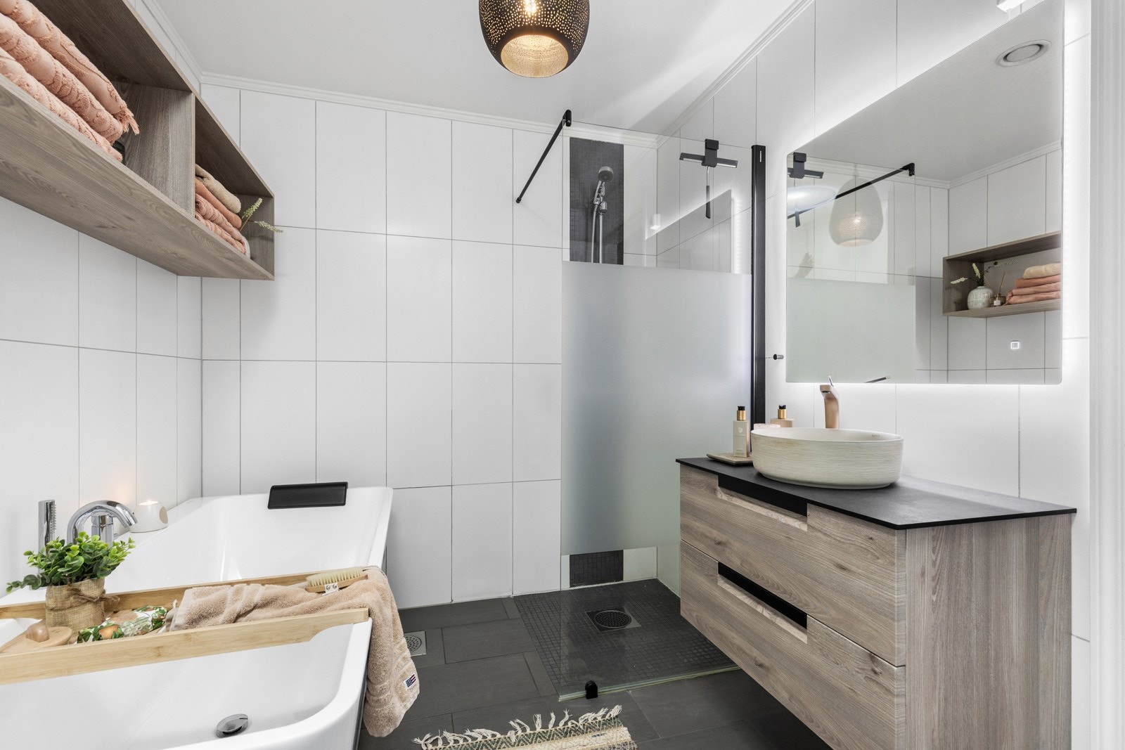 Lekkert bad med moderne innredning, dusjnisje, badekar og stilrene materialvalg som gir en avslappende spa følelse. Galleribilde