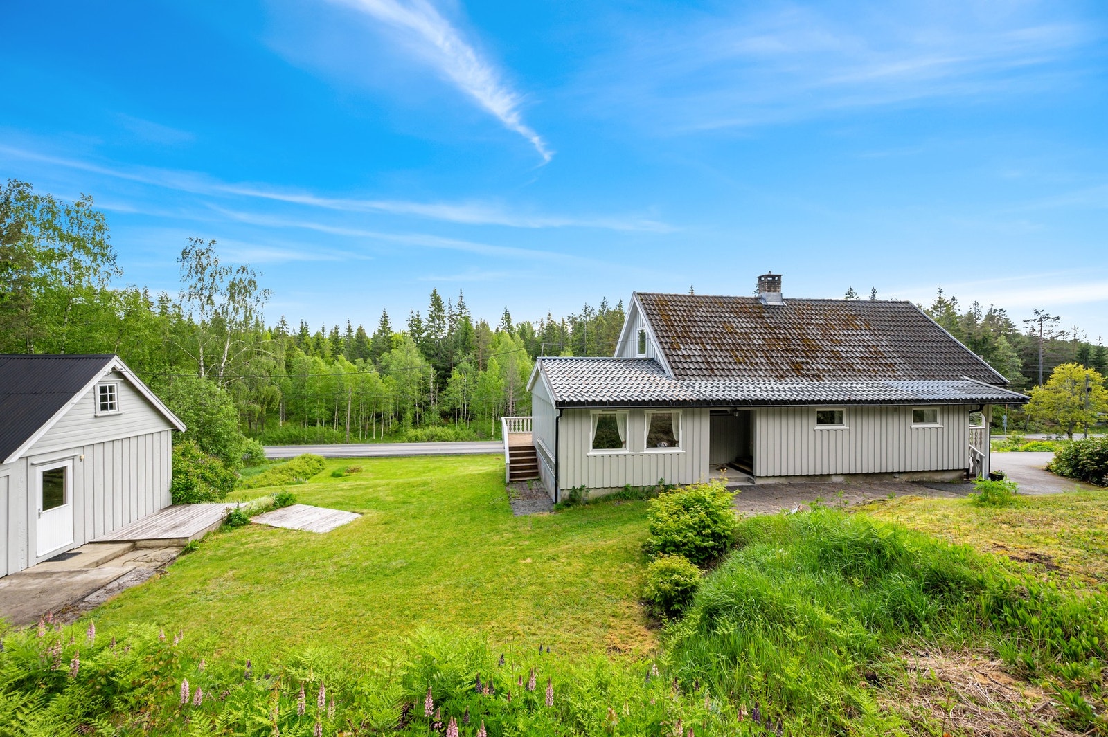 Eiendommen er godt opparbeidet med stor hage med plen, pryd busker, bedd og annen beplantning Galleribilde