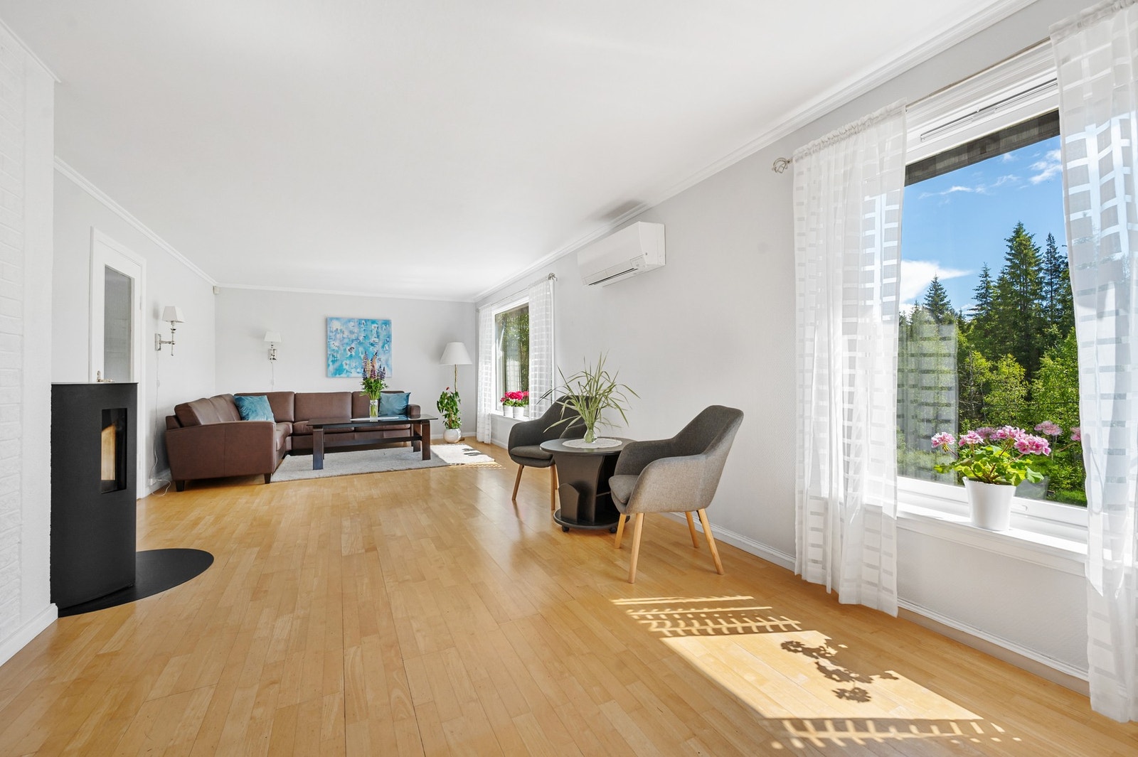 Stor stue med store vindusflater som slipper inn rikelig med naturlig lys. Galleribilde