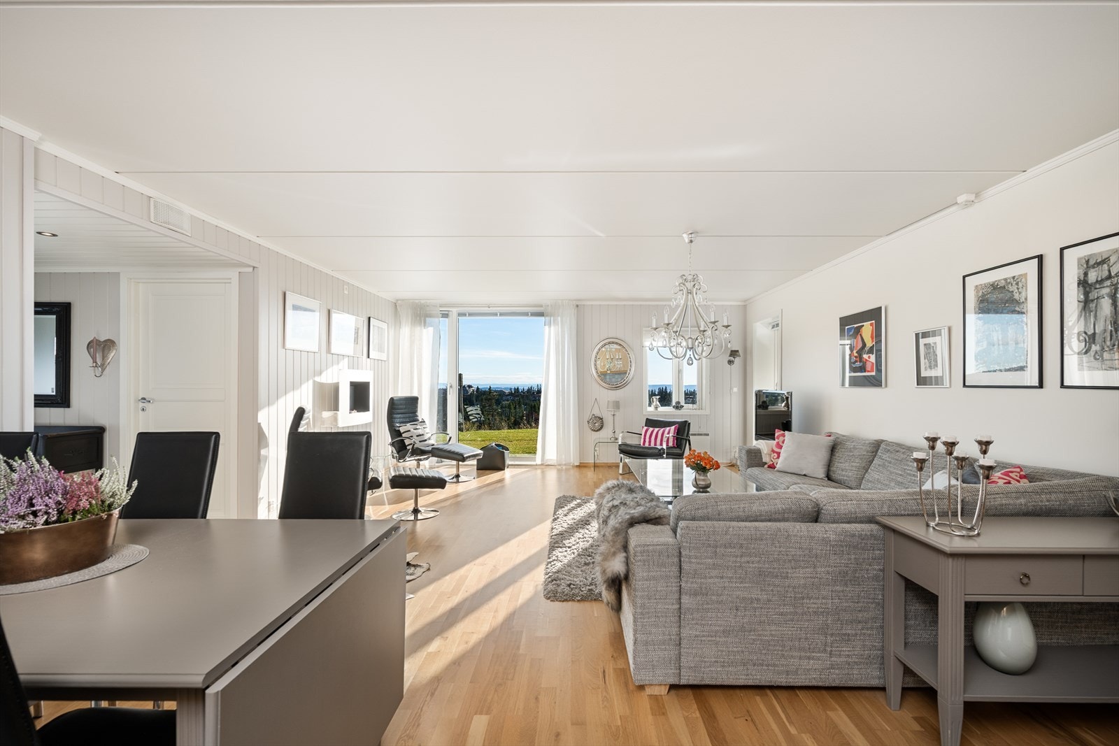 Lys og tiltalende stue med åpen løsning mot kjøkken og spiseplass. Galleribilde