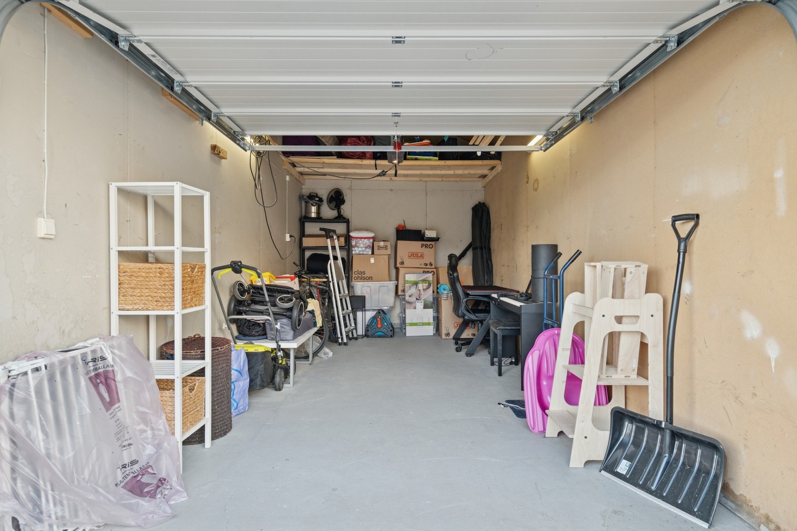 Fast parkering i garasje med el-port. Praktisk hems for ekstra oppbevaring. Galleribilde