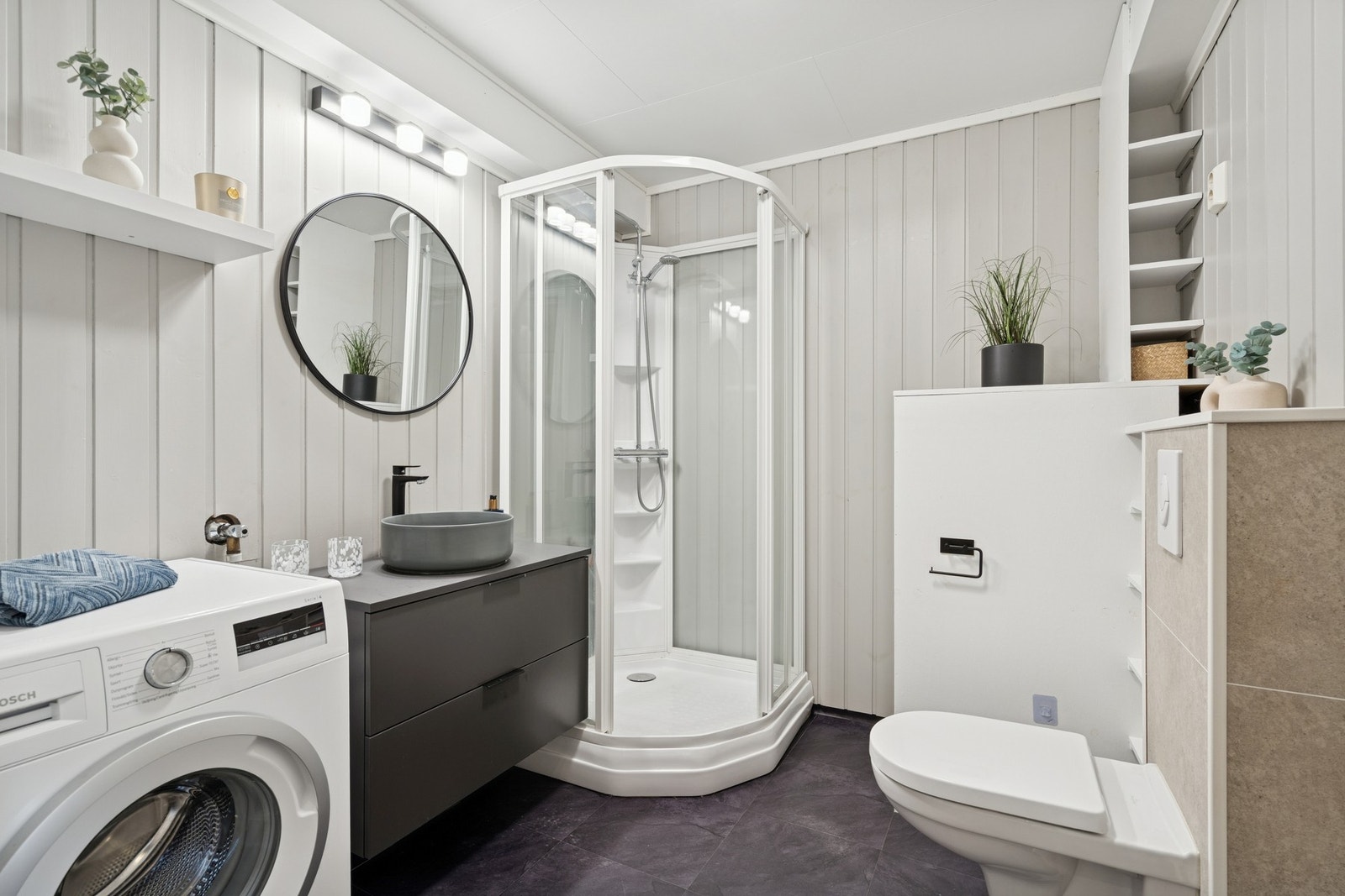 Stilrent bad med vegghengt WC, dusjkabinett og innredning med servant. Galleribilde