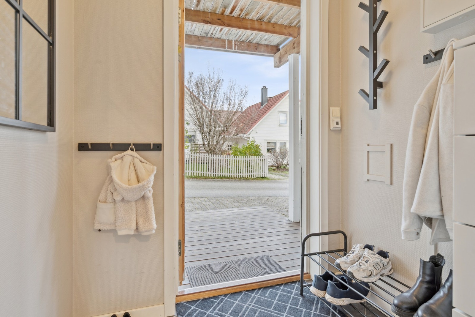 Flislagt entré med varme i gulv. Ekstra, praktisk oppbevaringsbod rett utenfor inngangsdøra. Galleribilde