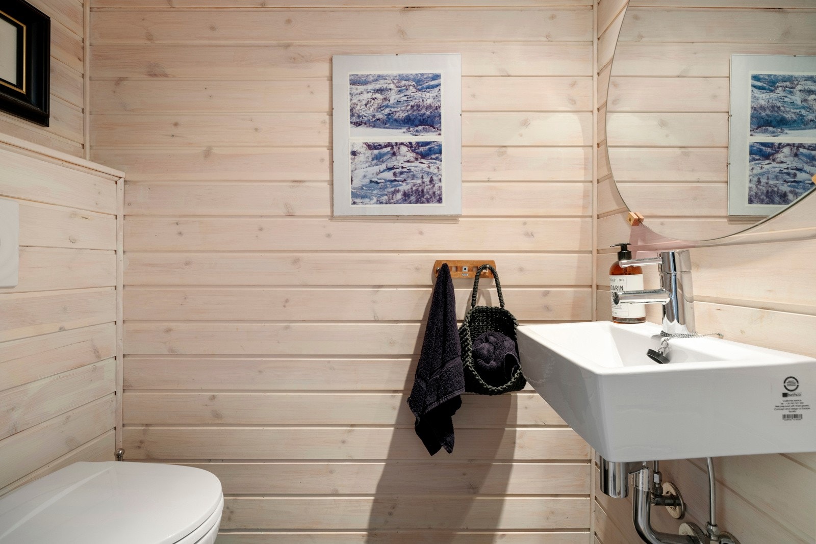 På wc-rommet er det vegghengt toalett og en enkel servant med tilhørende speil. Galleribilde