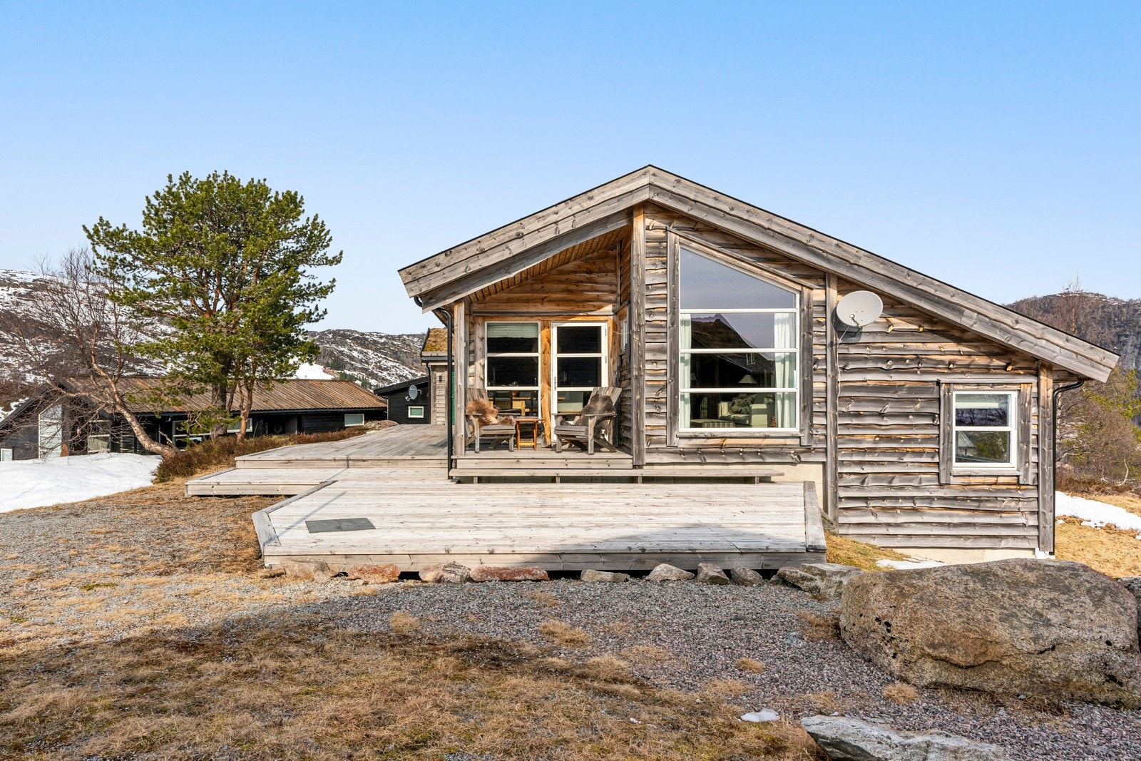 På fremsiden er en stor terrasse etablert rundt hytta, med ulike nivåer og adkomst fra hovedstuen. Galleribilde