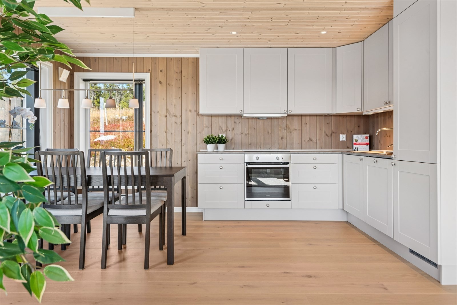 Praktisk kjøkken i åpen løsning med laminerte skrog og profilerte fronter. Galleribilde