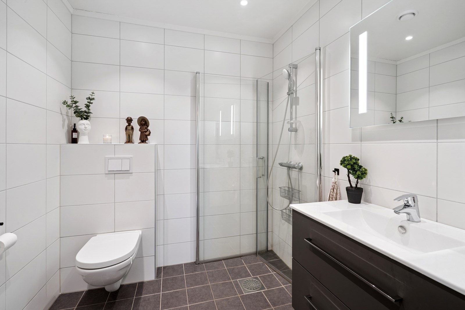 Lyst og tidløst bad med fliser på gulv og vegger. Galleribilde