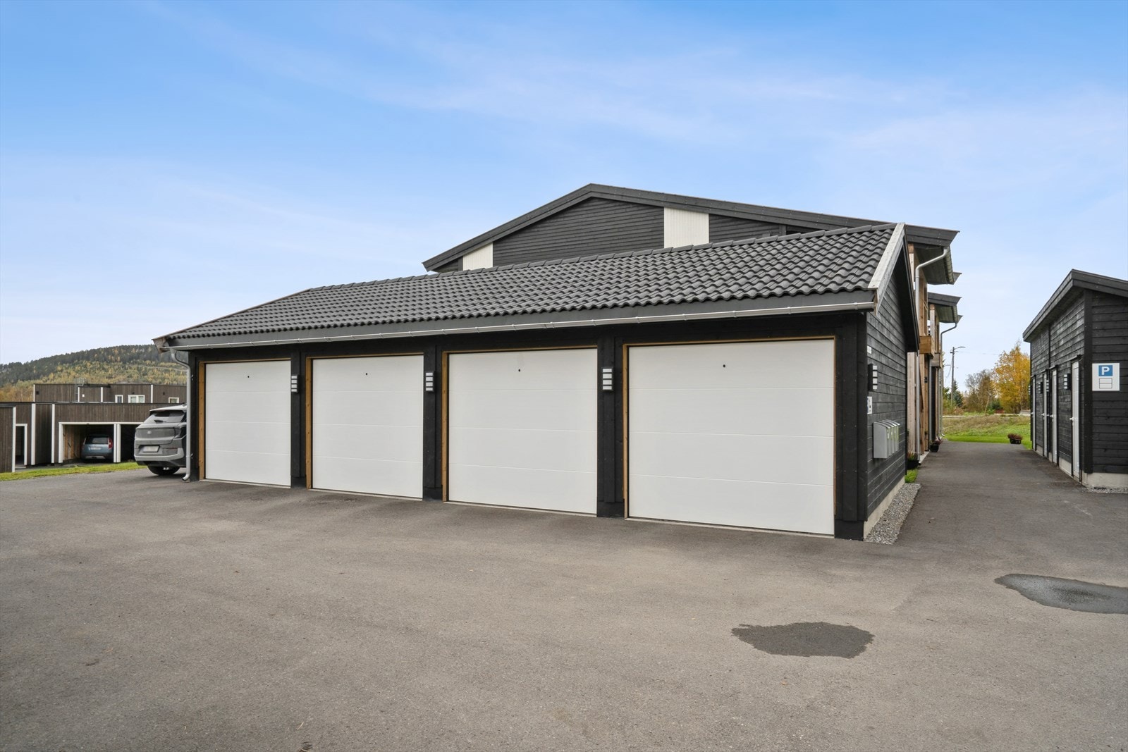 Garasje i rekke. Det er gjesteparkering på venstre side. Galleribilde