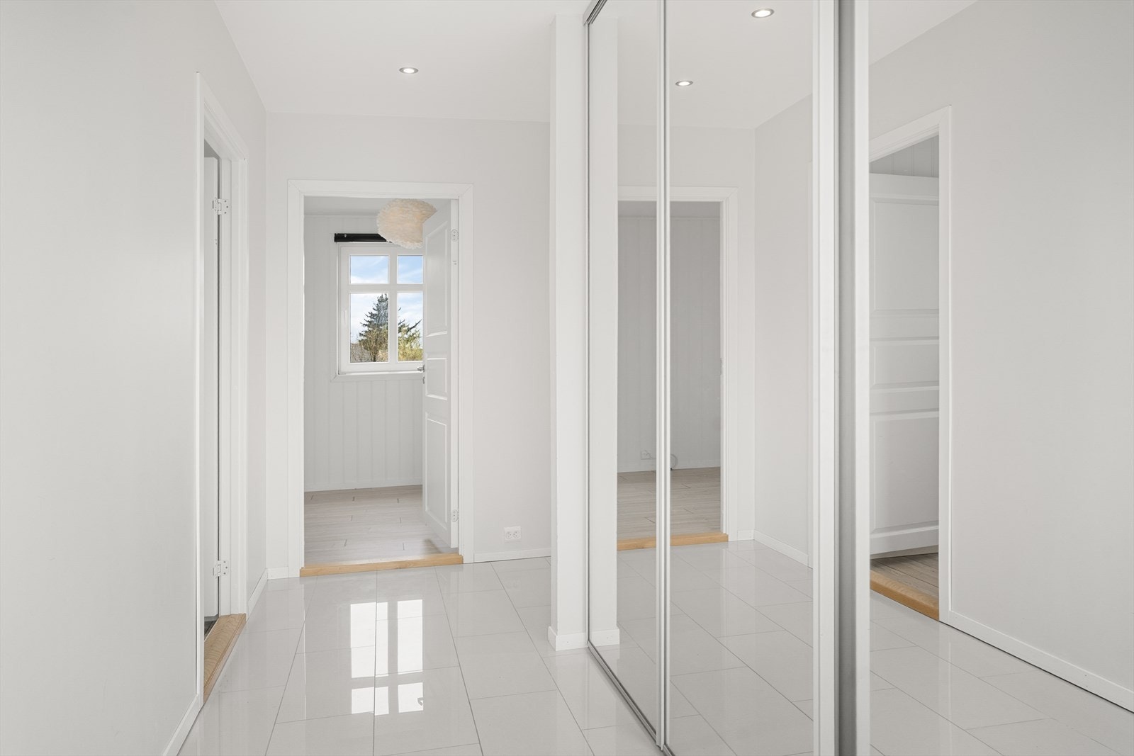 Gang med fliser på gulv og skyvedørs garderobe. Galleribilde