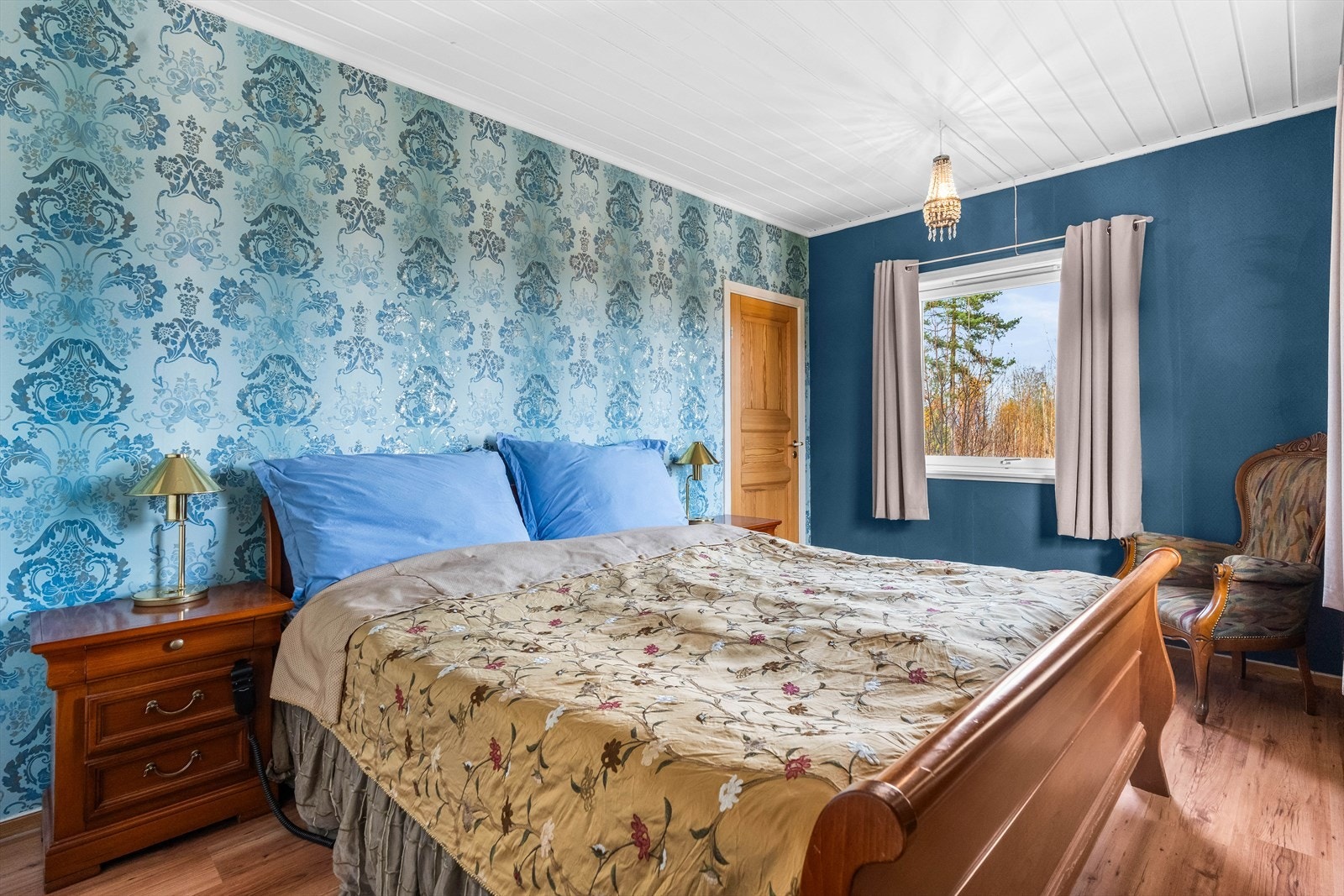 Store vindusflater fyller rommet med naturlig lys og skaper en varm og innbydende atmosfære. Galleribilde