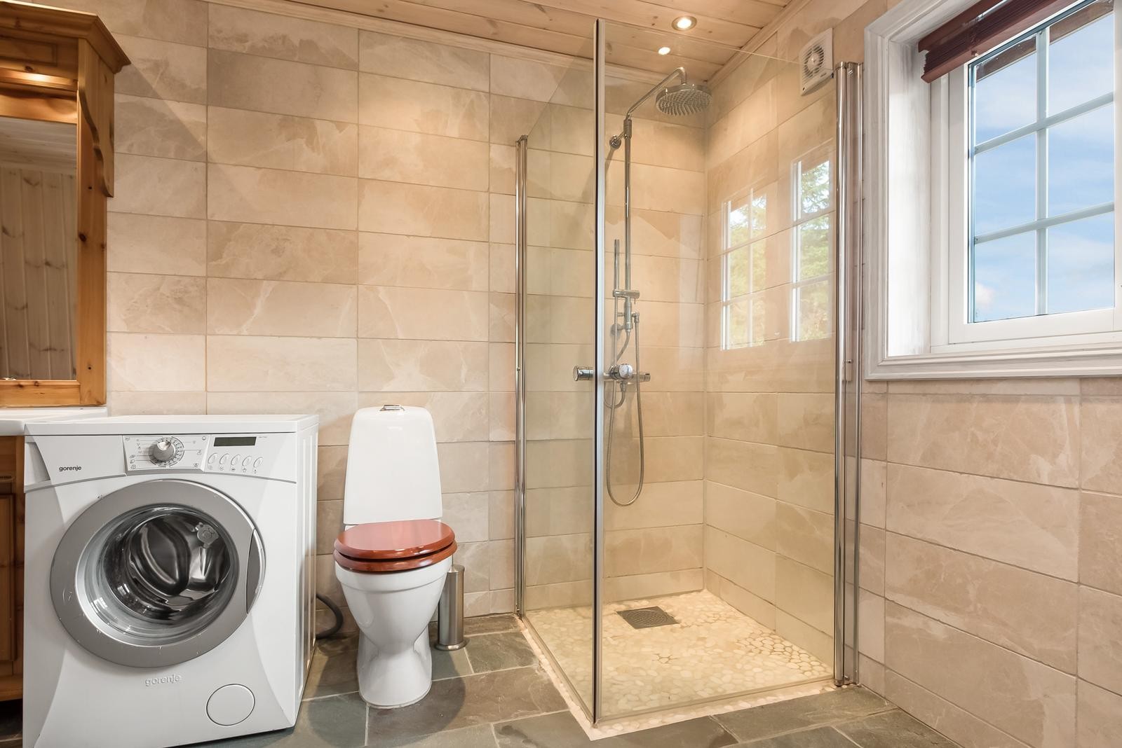 Pent bad innredet med dusjhjørne, toalett og servant på innredning. Galleribilde