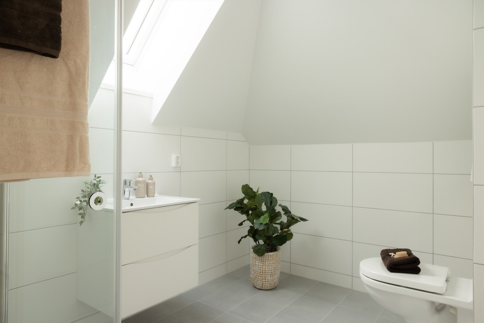 Badet har varmekabler i gulvet og inneholder servant med skuffer under, dusjhjørne samt vegghengt toalett. Galleribilde