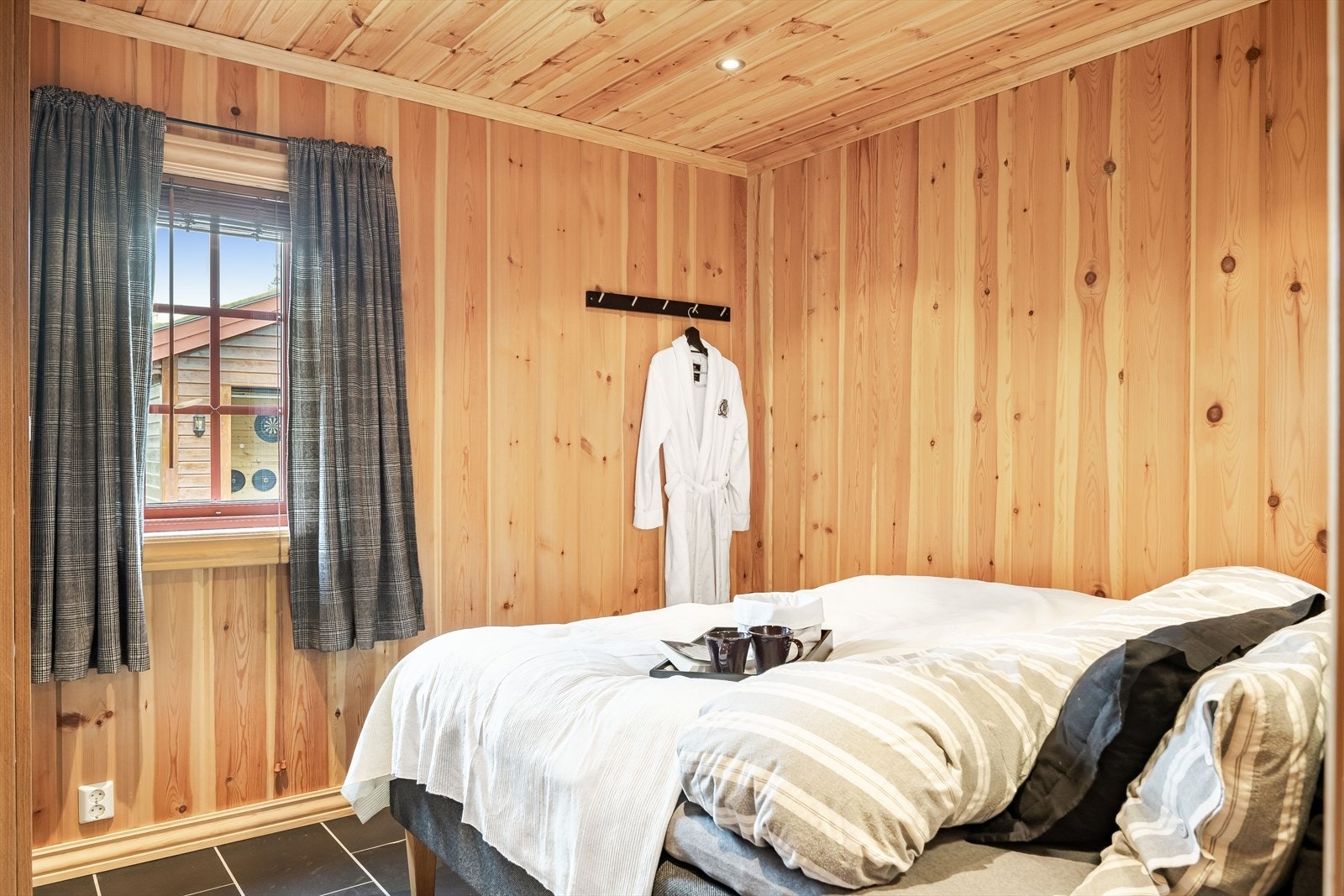 Soverom 1 er et hyggelig rom som i dag er innredet som et hovedsoverom med dobbeltseng. Soverommet har deilig vannbåren gulvvarme, lun trepanel på veggene og downlights i himlingen. Galleribilde