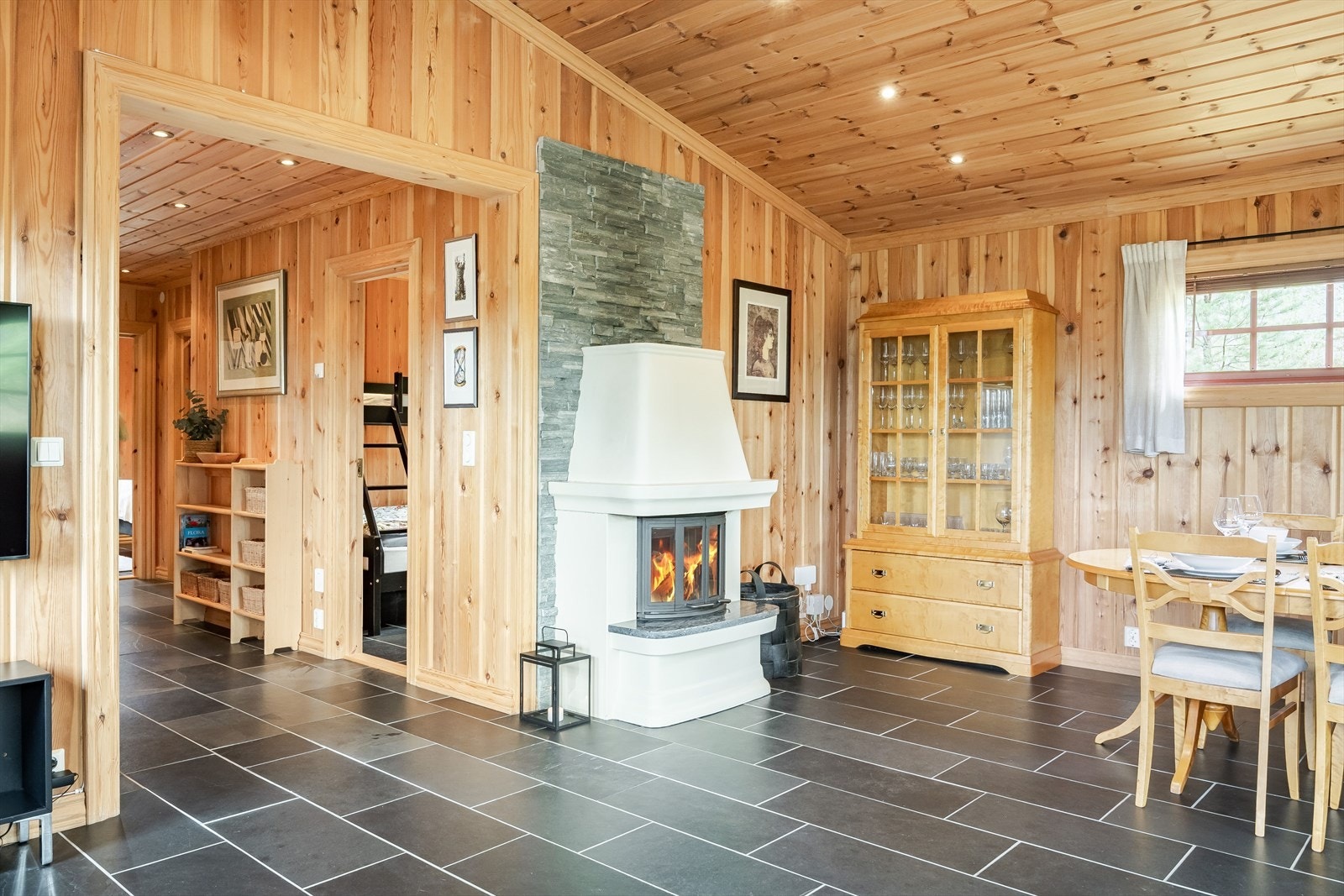 God standard med mørke fliser på gulv, vannbåren gulvvarme, skjult elektrisk anlegg og downlights i himlingen. Veggen bak peisen er dekorert med kleberstein. Galleribilde