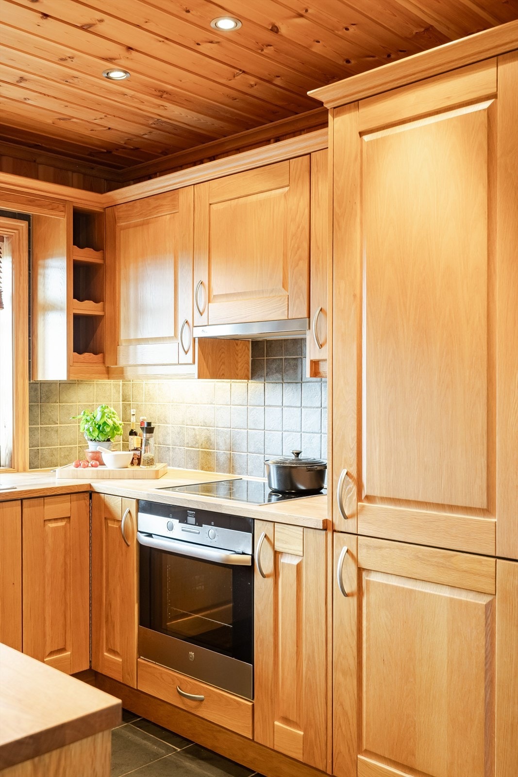 Praktisk med fliser i benkeryggen og belysning under overskapene i tillegg til downlights i himlingen. Galleribilde