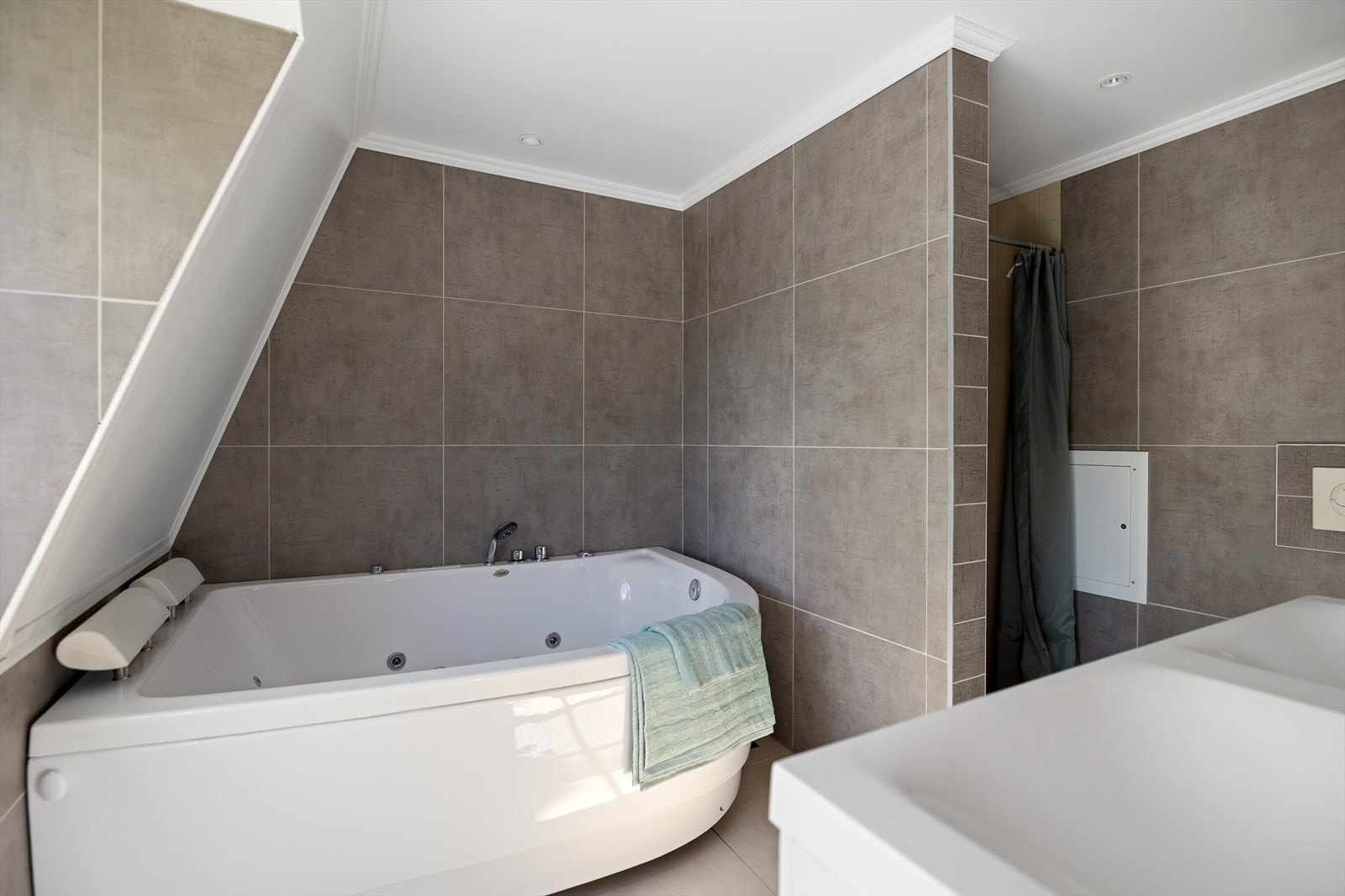 For den som ønsker avslapning etter en lang dag, byr det romslige hjørnebadekaret med massasjedyser på en ekte spa-følelse i eget hjem. Dusjnisjen gir en mer praktisk løsning for travle dager. Galleribilde