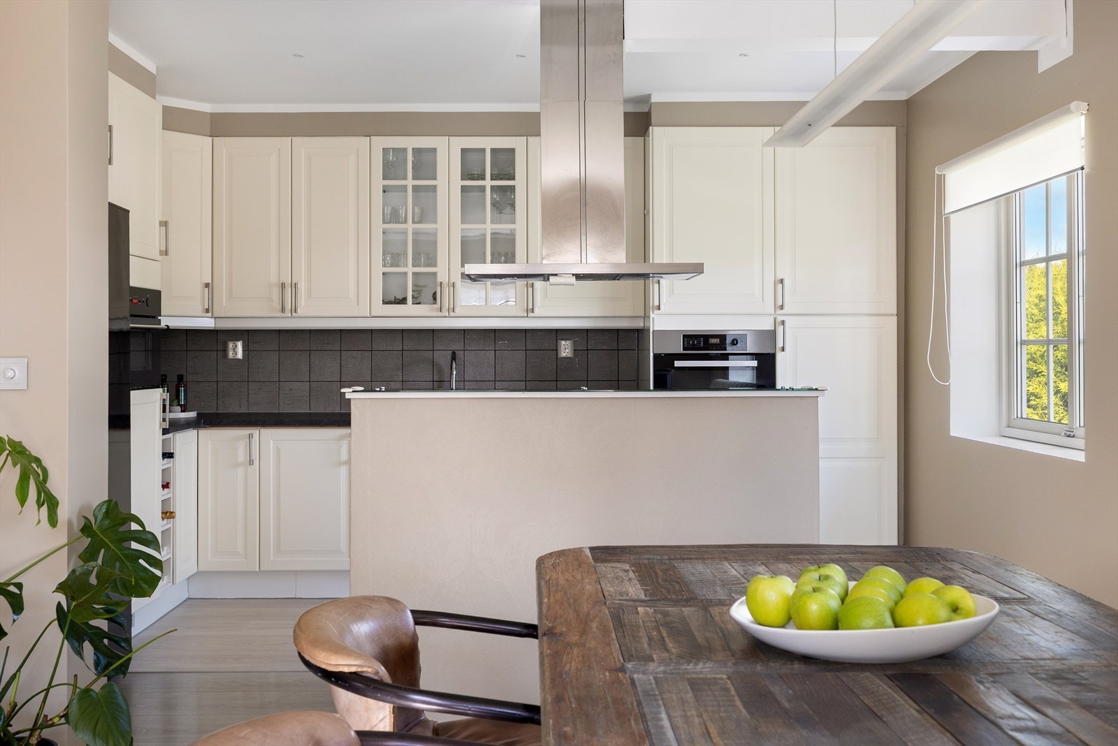 Kjøkkenet fremstår som både funksjonelt og innbydende, med en klassisk innredning med profilerte fronter og en ny benkeplate fra 2025. Galleribilde