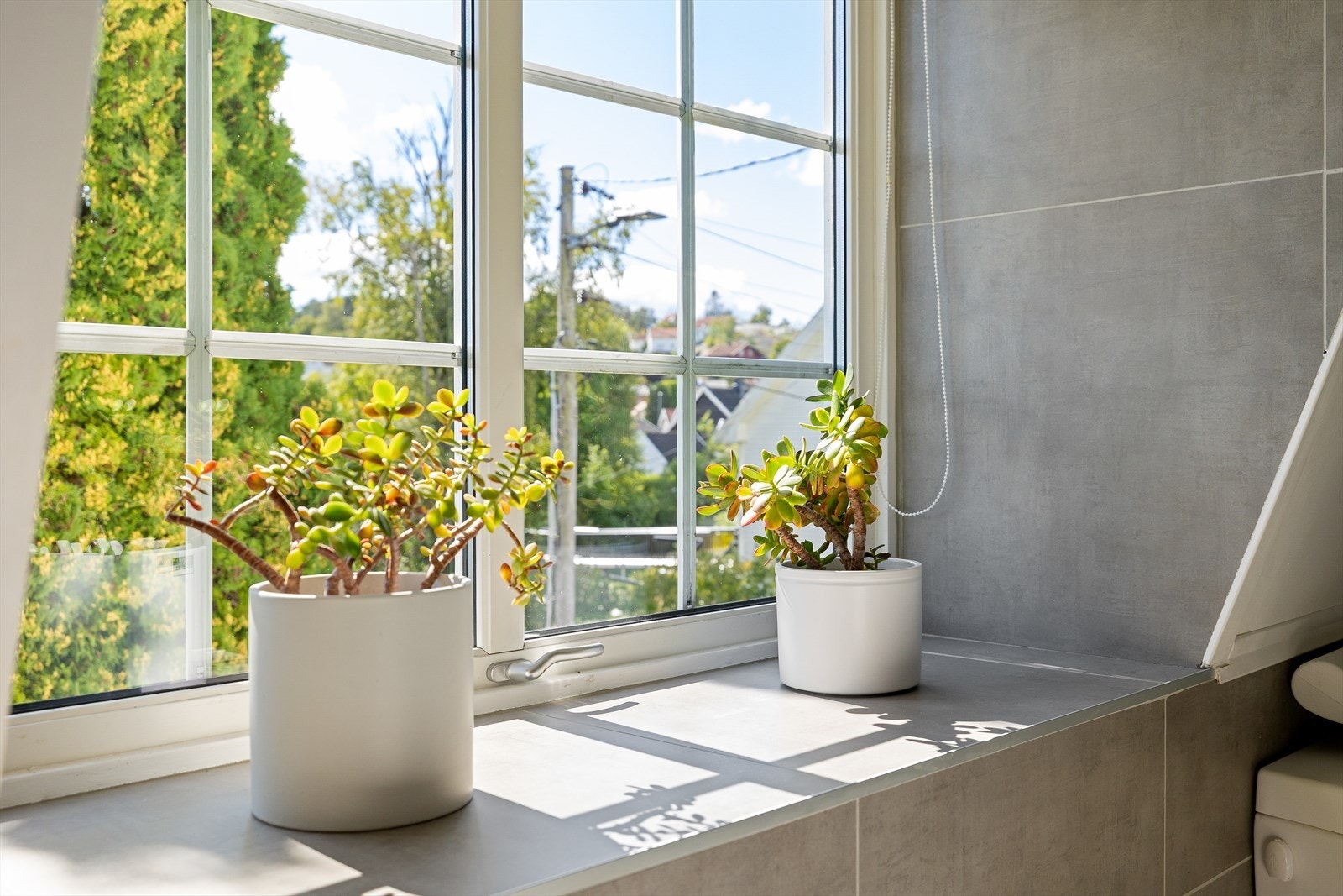 Baderommet har et stort vindu som slipper inn rikelig med naturlig lys. Den brede vinduskarmen gir i tillegg en dekorativ mulighet - perfekt for å sette sitt personlige preg med blomster, planter eller annen pynt som skaper en hyggelig stemning. Galleribilde