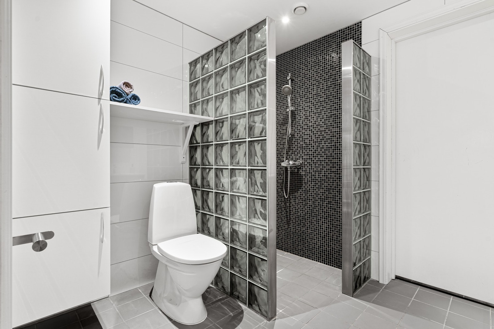 Romslig dusjsone og rikelig med skap for oppbevaring. Galleribilde