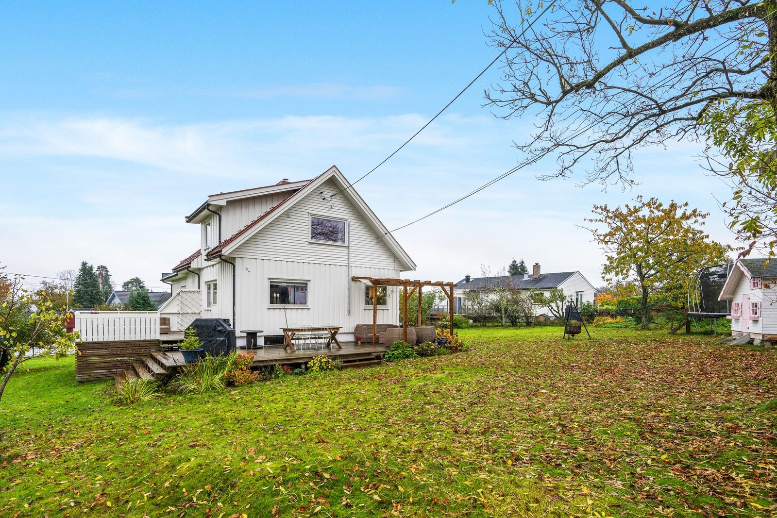 Stor terrasse med tilhørende platting og dør inn til stua Galleribilde