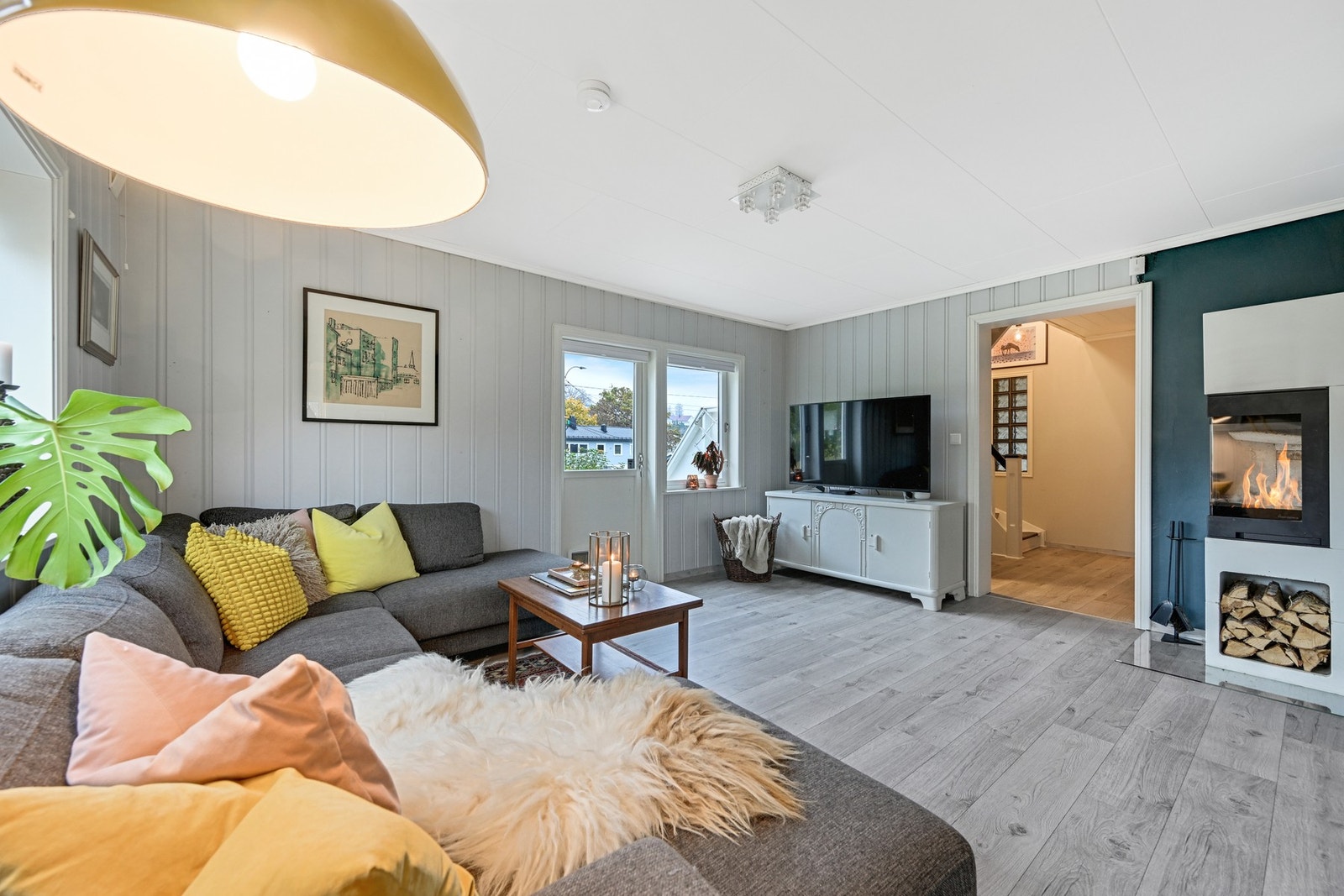 Lys og koselig stue med gjennomlys og stilig peisovn Galleribilde