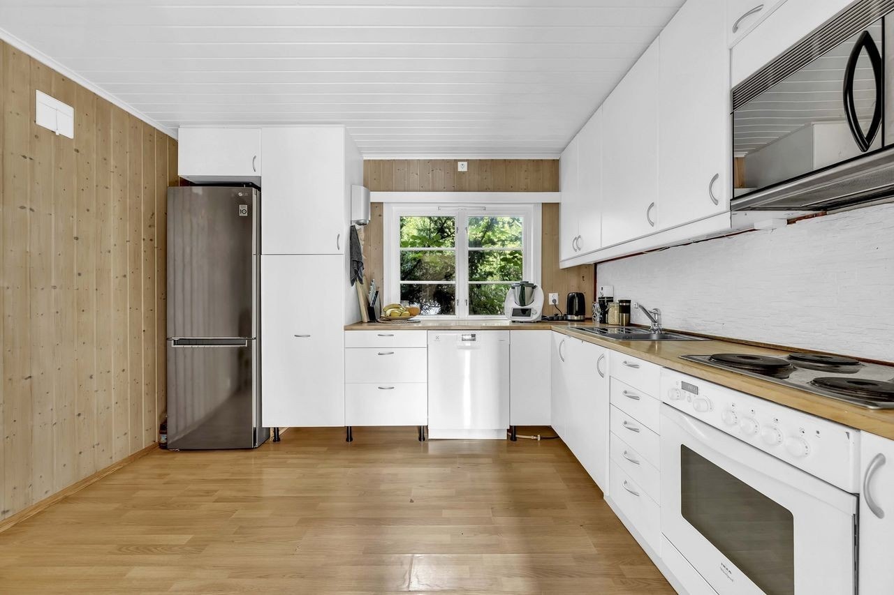 Romslig kjøkken med lys innredning. Galleribilde