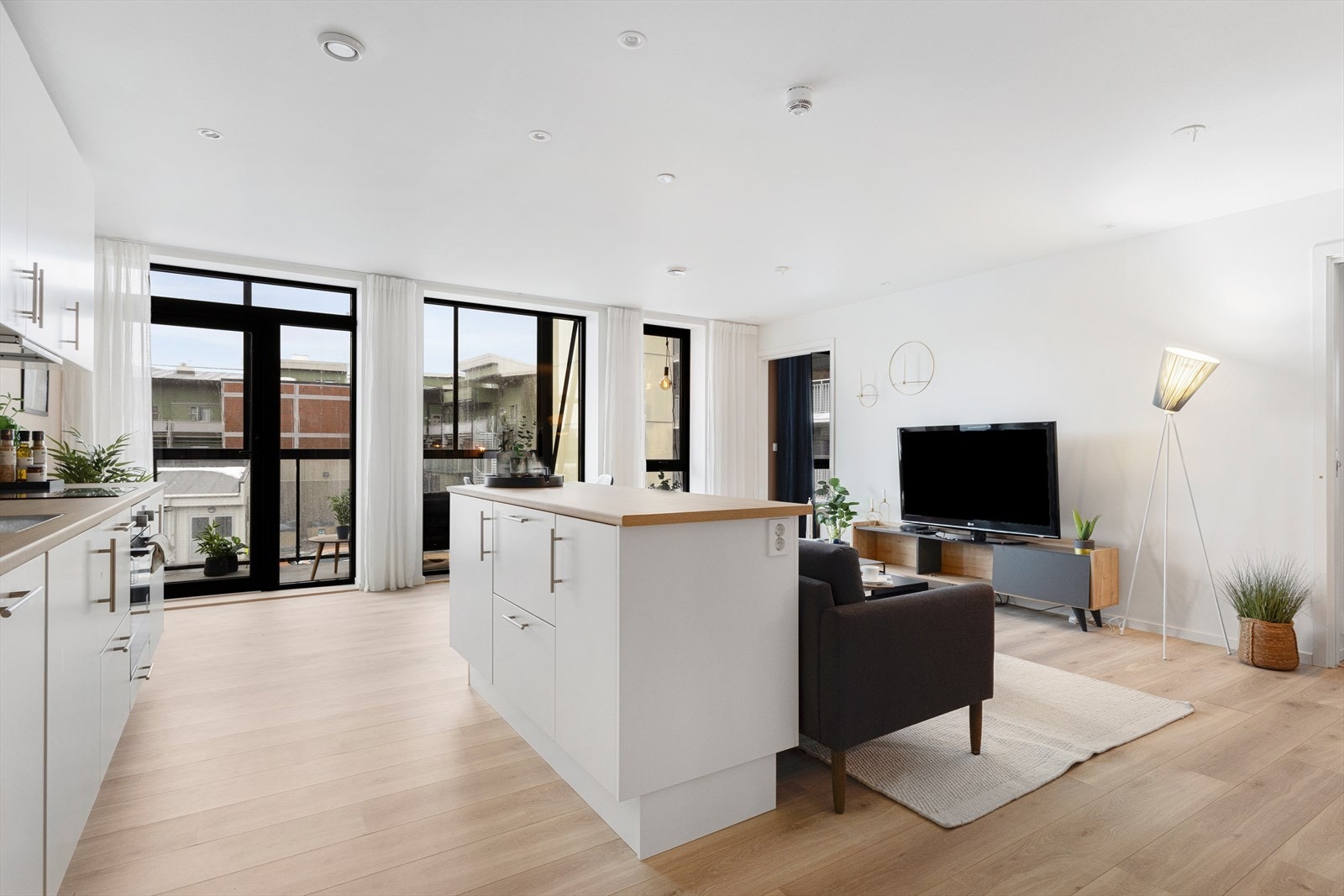 Den åpne kjøkken- og stueløsningen skaper en sosial arena hvor kjøkkenøyen er praktisk plassert slik at sofaen enkelt kan plasseres bak. Galleribilde