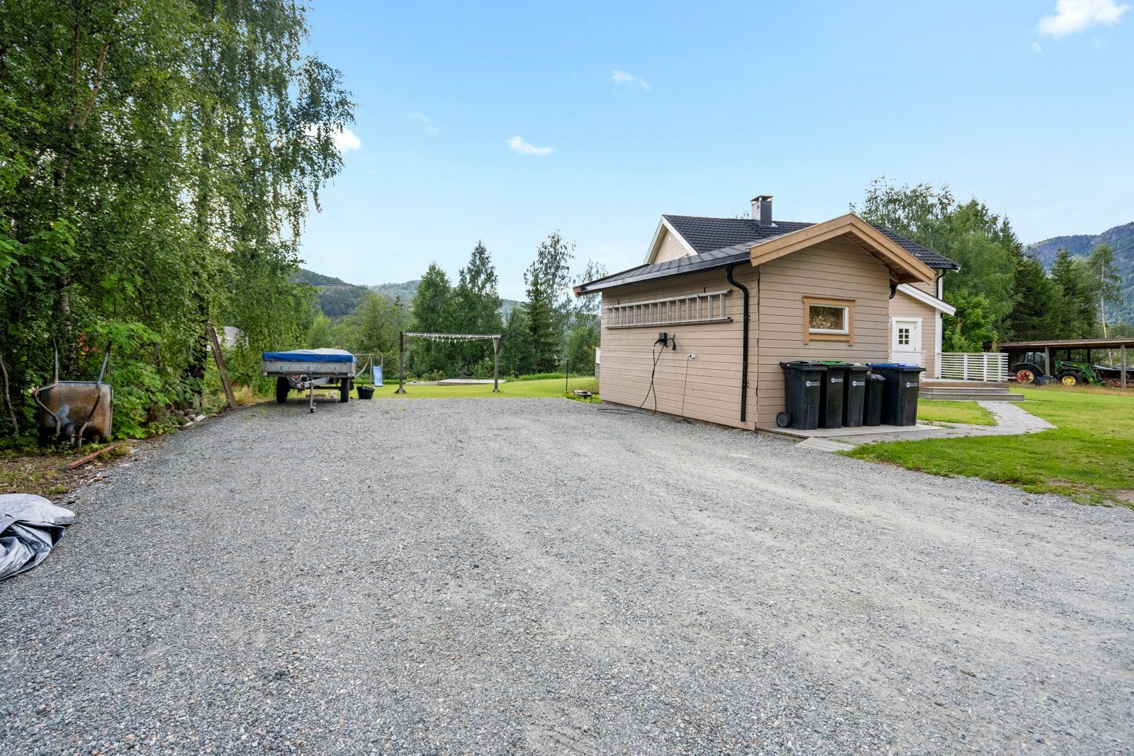 Stor parkeringsplass med elbillader fra Zaptec på ytterveggen til uthuset. Galleribilde