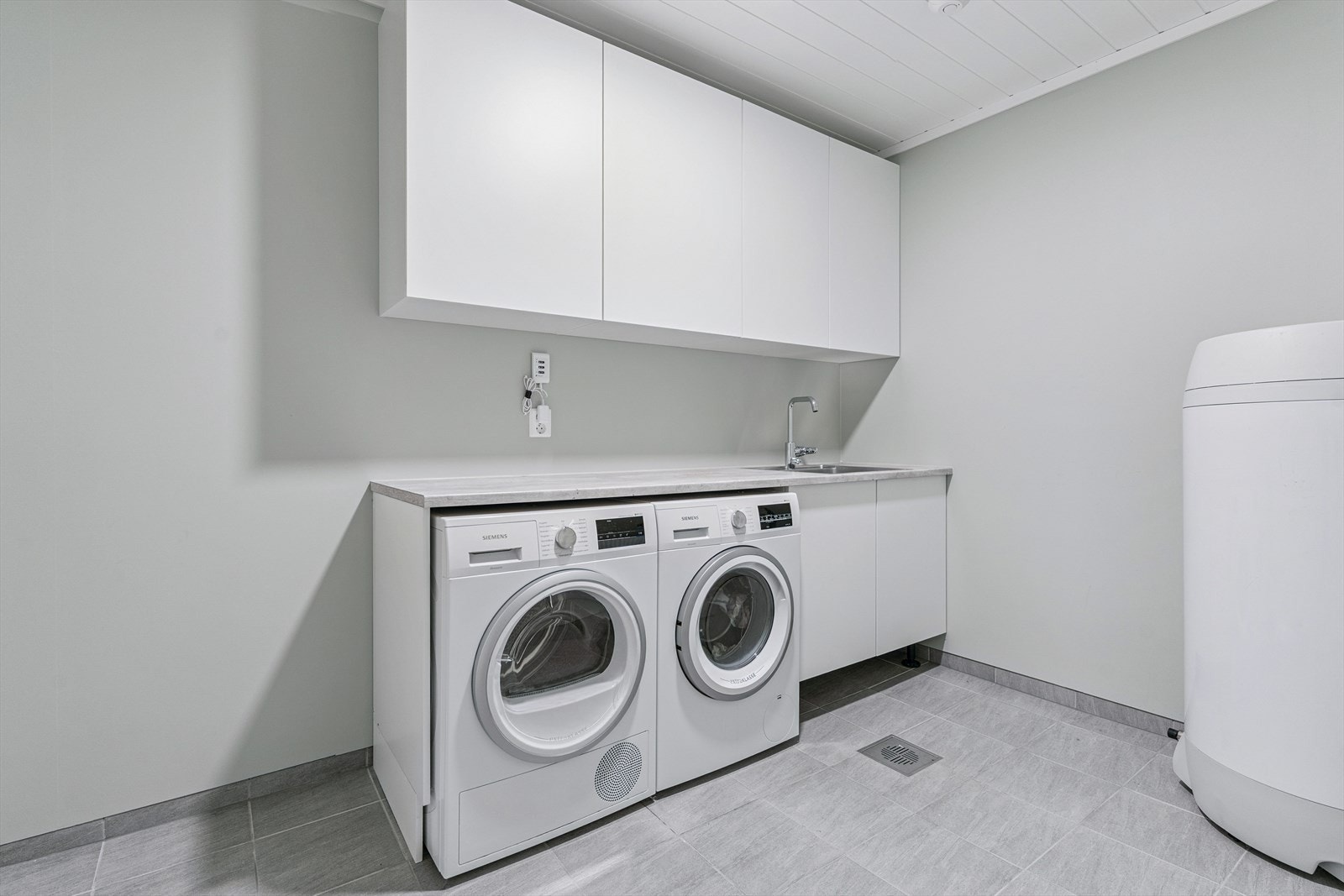 Vaskerom i underetasje. Flis på golv med varmekablar og malte plater på veggar. Galleribilde