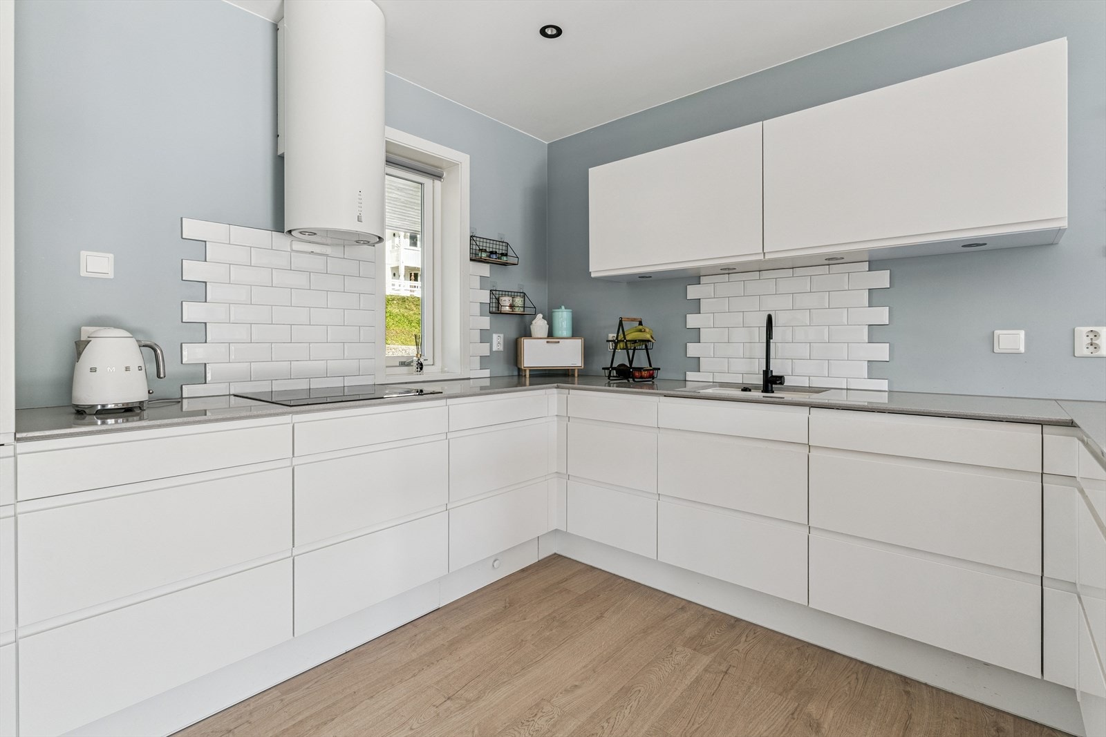 Innreiinga frå JKE har kvite, glatte frontar og ei grå benkeplate i stein. Galleribilde