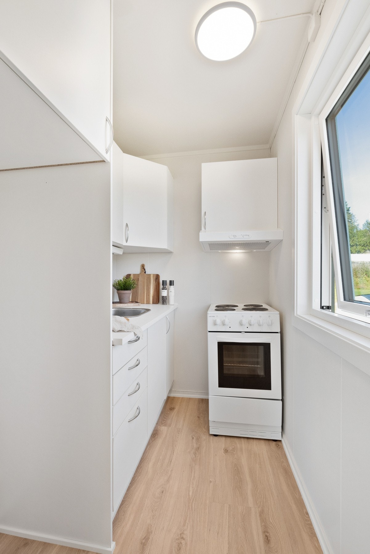 Arealeffektivt kjøkken med plass til komfyr og kjøleskap. Galleribilde