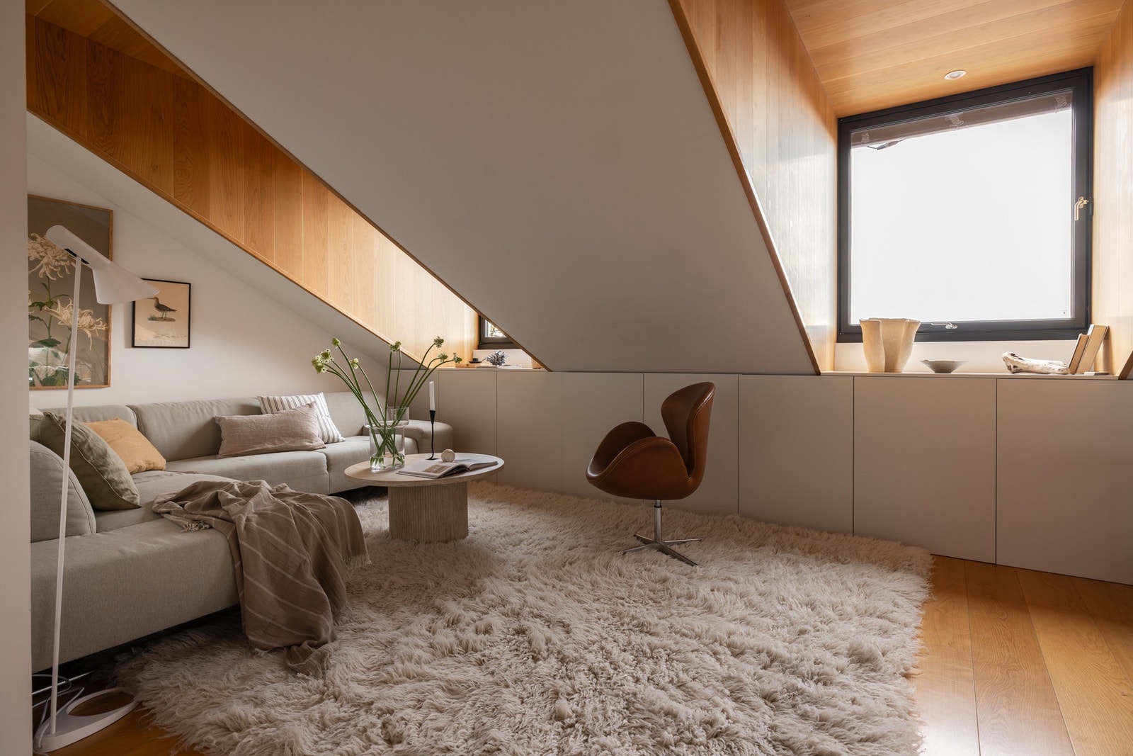 Lys og romslig loftsstue med hyggelig hjørnesone. Perfekt som ekstra oppholdsrom med direkte tilgang til takterrassen. Galleribilde