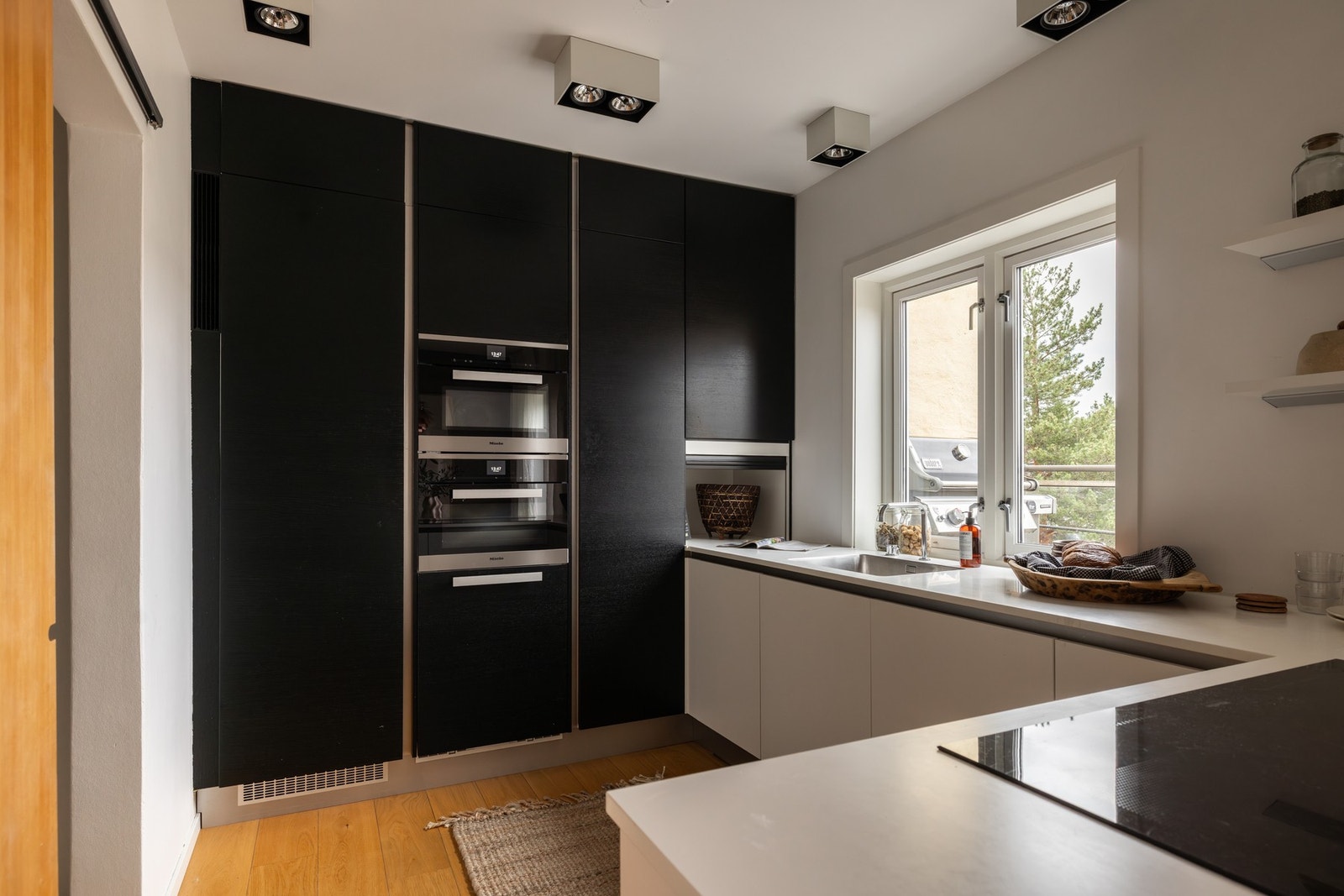 Integrert 90 cm Miele induksjonstopp med nedfelt benkeventilator gir et rent og sømløst uttrykk når den ikke er i bruk. FLOS Compass Box-belysning gir svært godt arbeidslys på benkene. Galleribilde