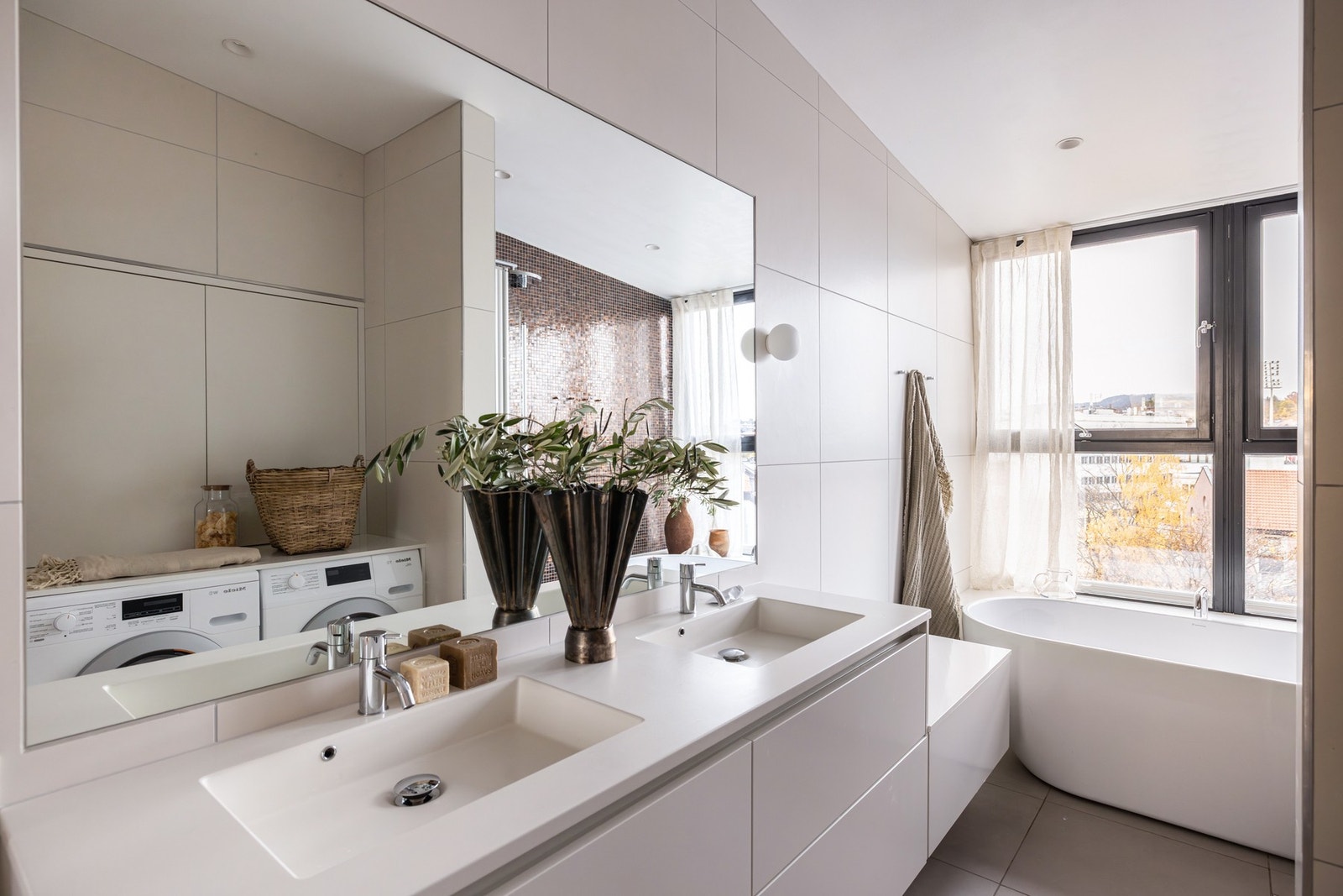 Plassbygde skap ved vask og over vaskemaskin/tørketrommel gir gode oppbevaringsløsninger og et rent uttrykk. Galleribilde