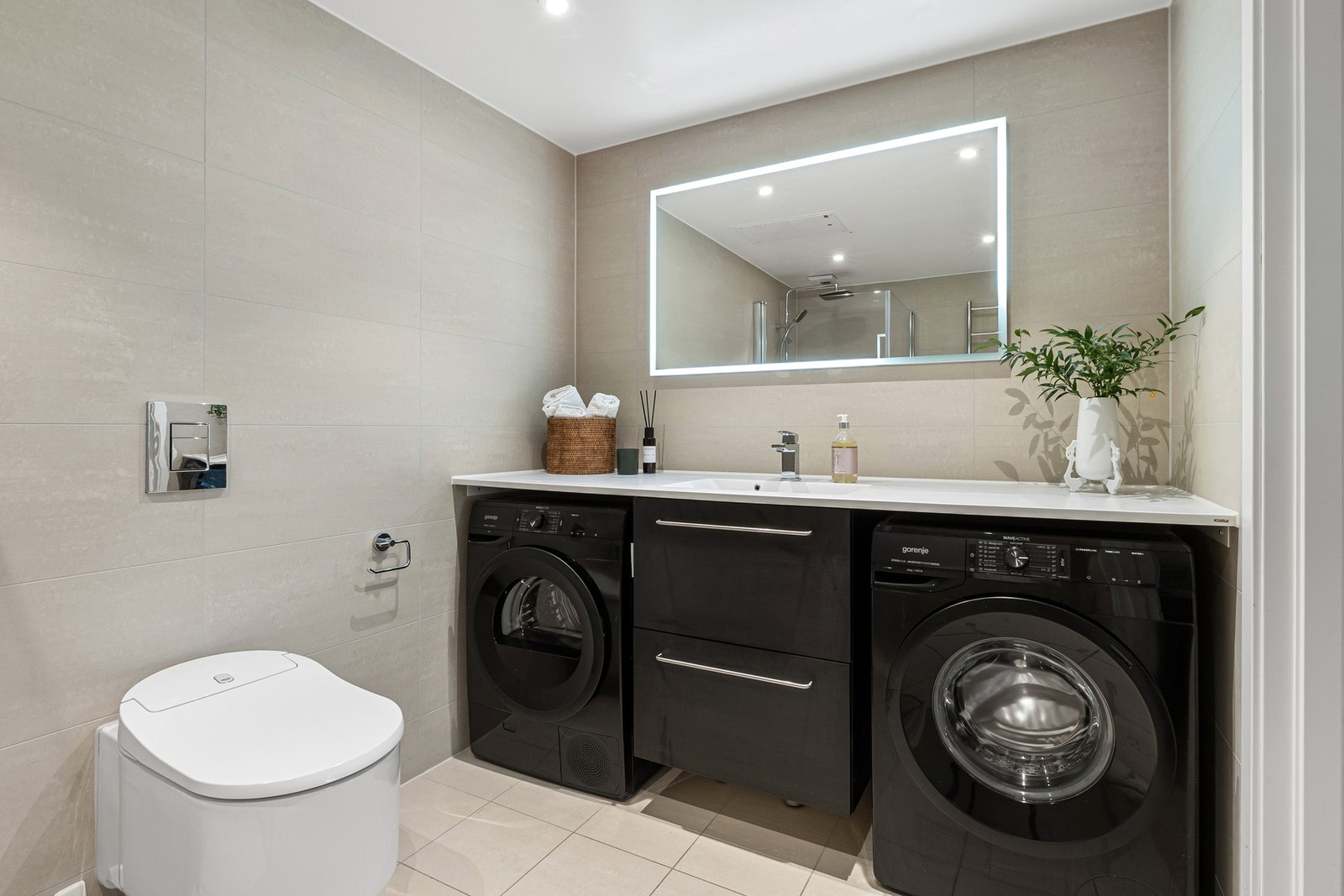 Det ene badet har servantinnredning, speil med lys, håndkleholder med varme, vegghengt toalett med fjernstyring med flere funksjoner og dusjhjørne med svingbare glassdører. Galleribilde