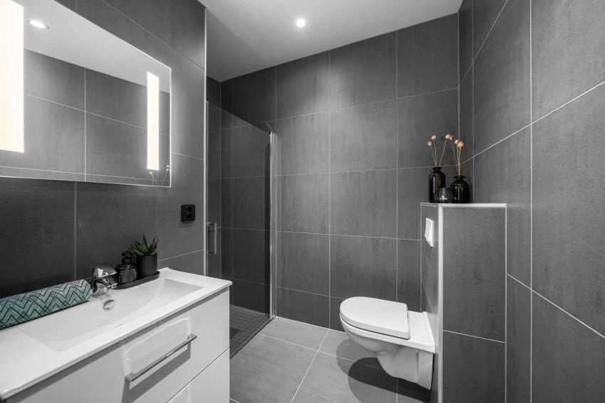 Delikat flislagt bad m/gulvvarme i boligens loftetasje, i tillegg til smakfulle storformatfliser på vegger og gulv i tidsriktig farge. Innredningen består av stilrent servantmøblement med skuffer, speil, vegghengt toalett. Galleribilde