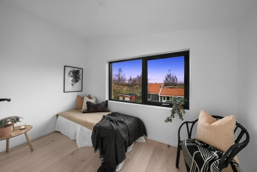 Soverom 3 fremstår som et koselig soverom med malte slette veggflater, lyspigmentert enstavs parkett på gulv og store vindusflater som slipper inn rikelig med lys Galleribilde