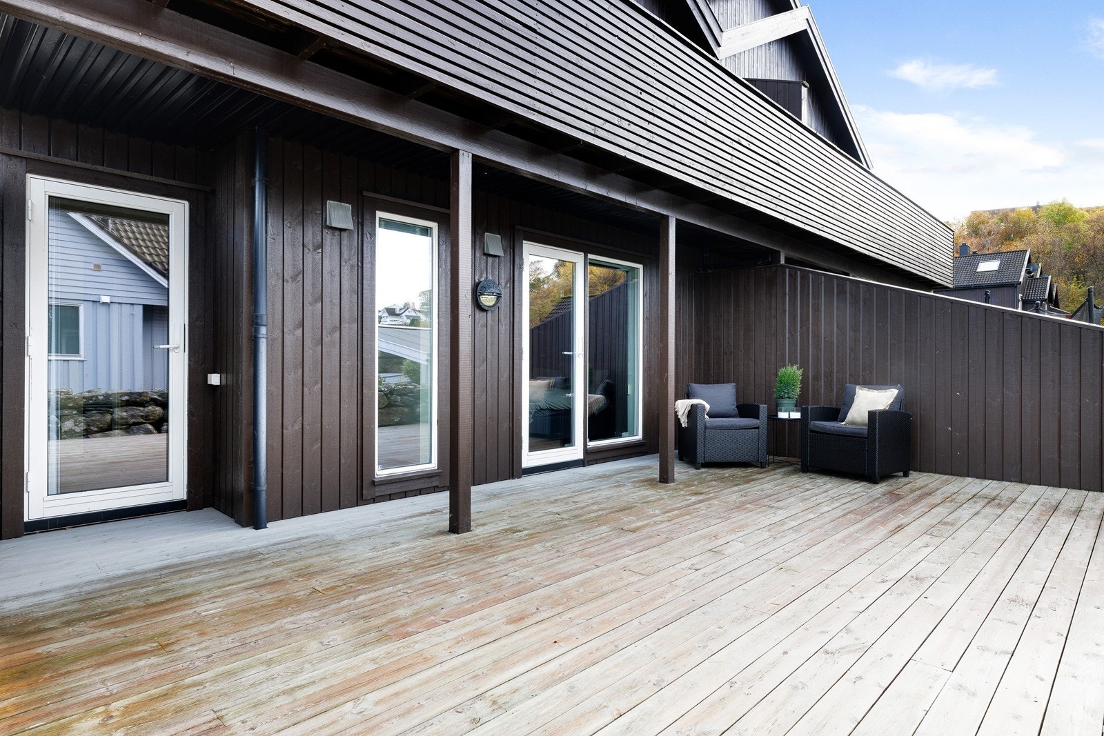 Stor solrik terrasse på bakkeplan, med skjerming mot nabo. Galleribilde