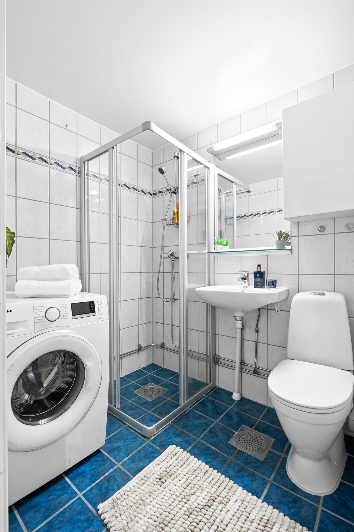 Badet ble rehabilitert i regi av borettslaget i 2003 og har varmekabler, gulvmontert toalett og et dusjhjørne med to skyvbare dører av glass. Badet har opplegg for vaskemaskin. Galleribilde